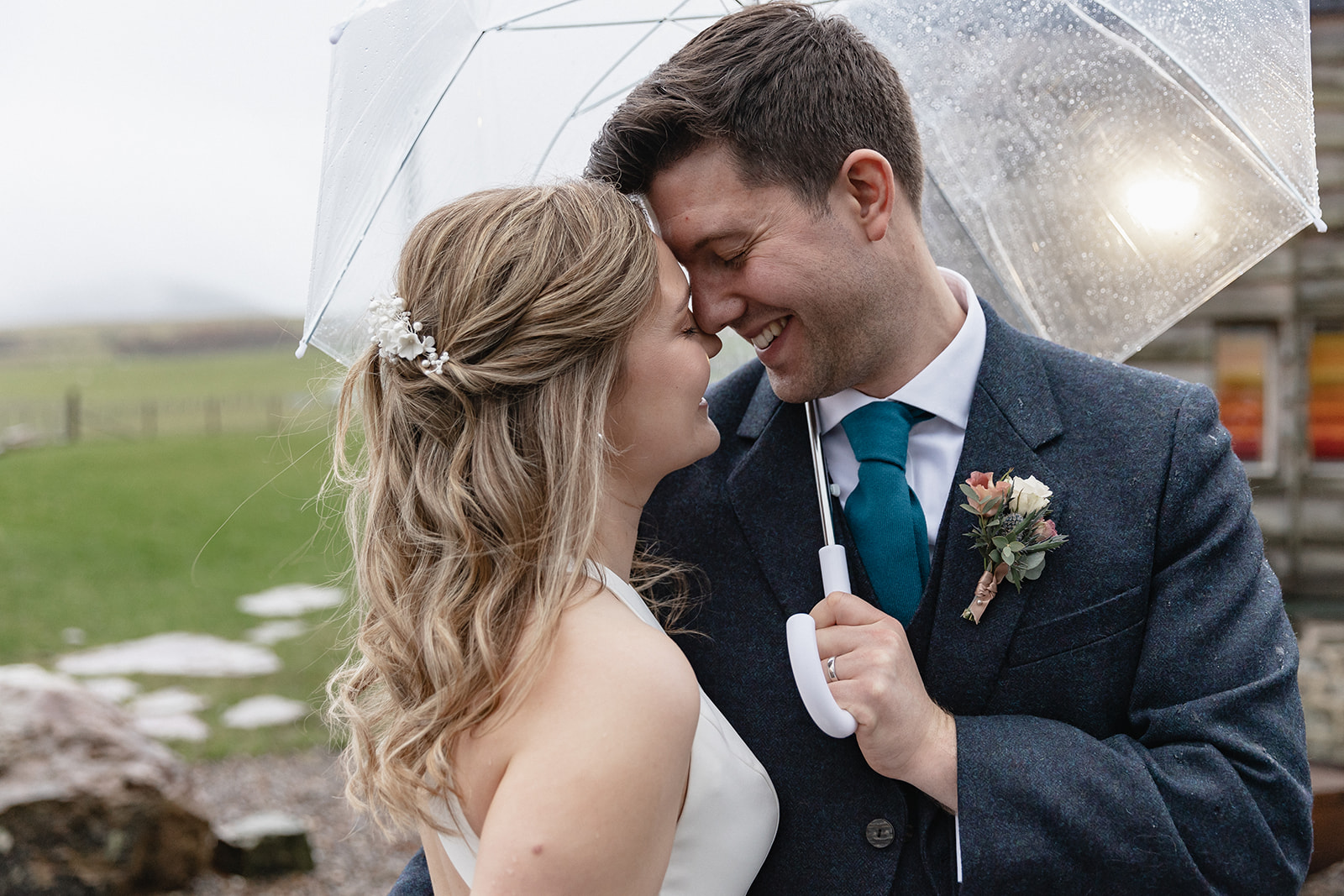 wedding couple in the rain under an umbrella at Cairns Farm Estate Silo