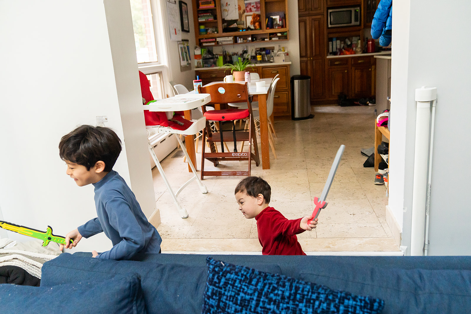 little brother chasing big brother with a sword