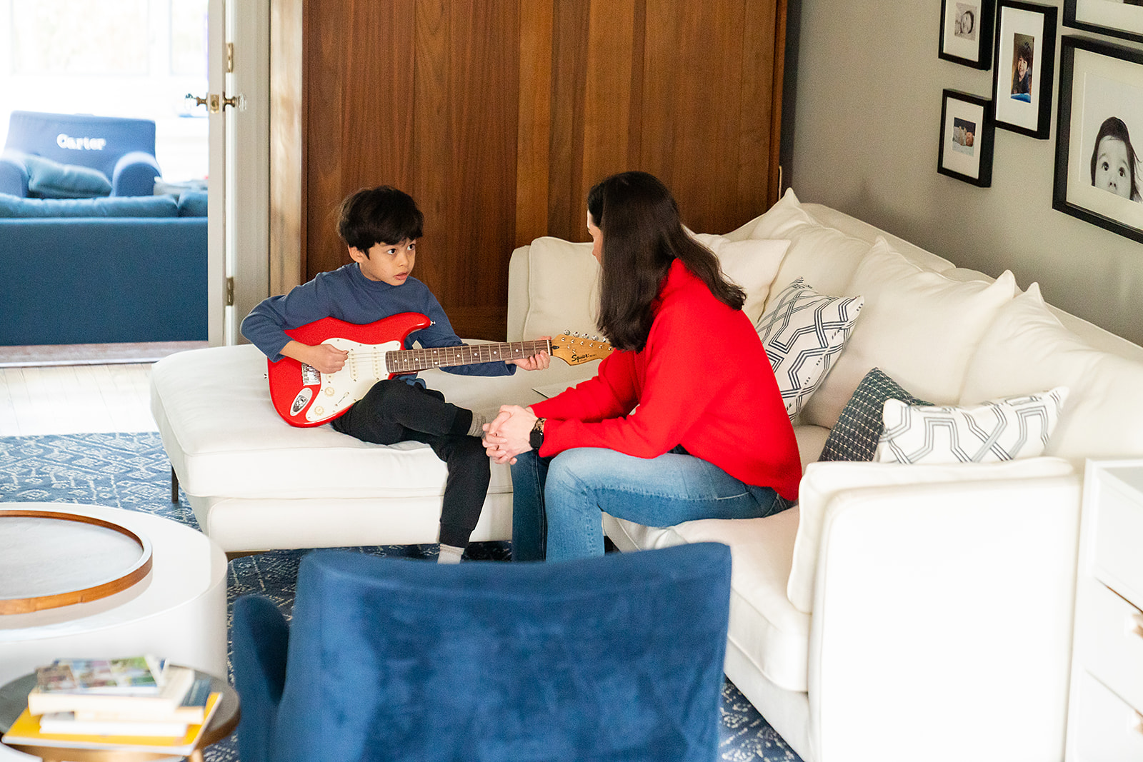 mom helping son learn guitar