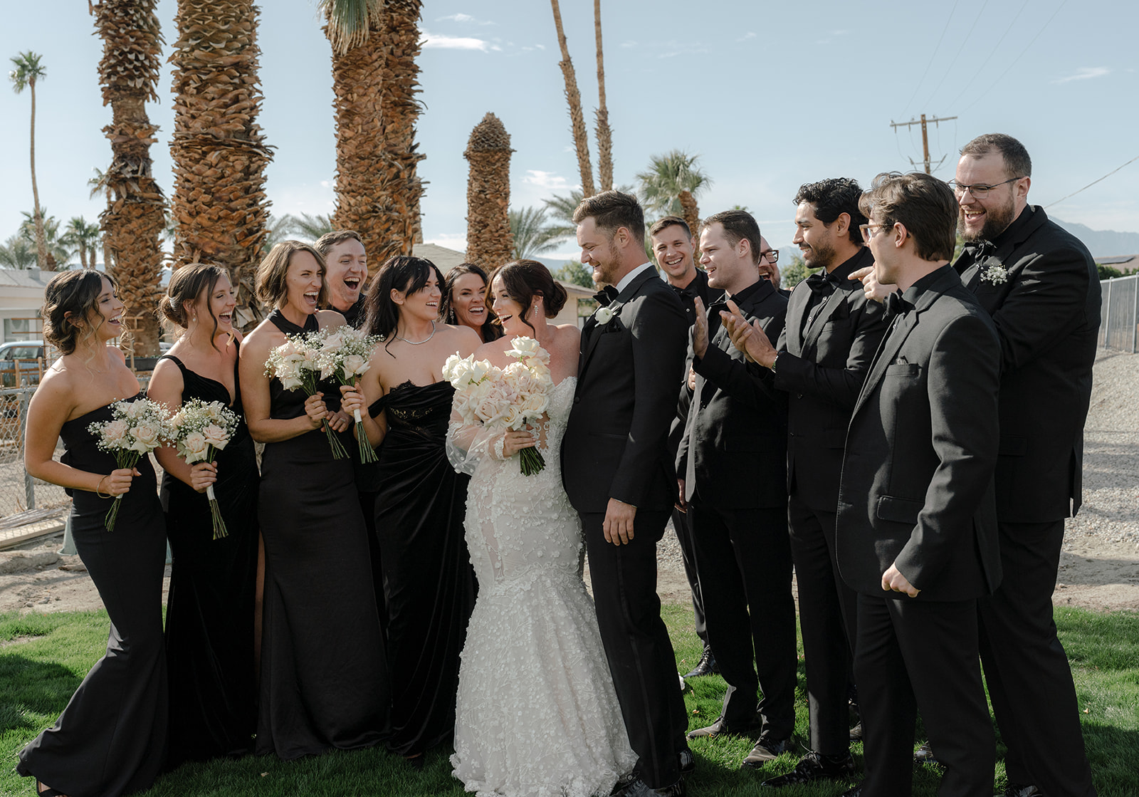 A newlywed couple and their bridal party laugh together