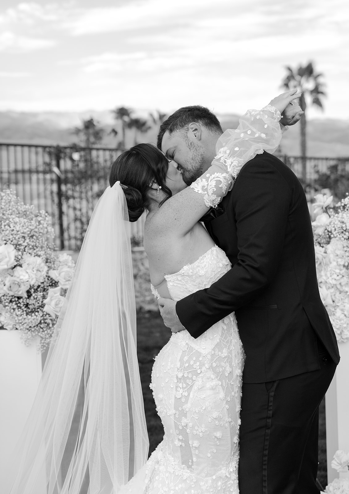 A newlywed couple shares their first kiss at their wedding in the desert