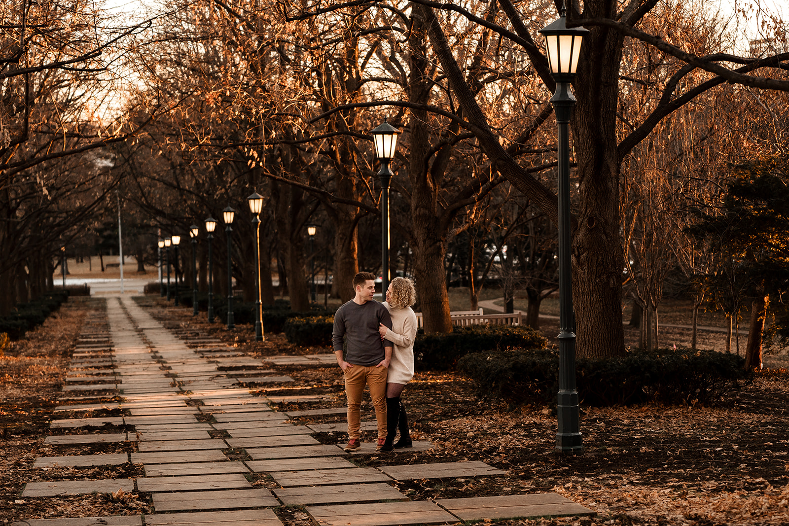 An engaged couple walking the grounds of the Nelson Atkins Museum in KC
