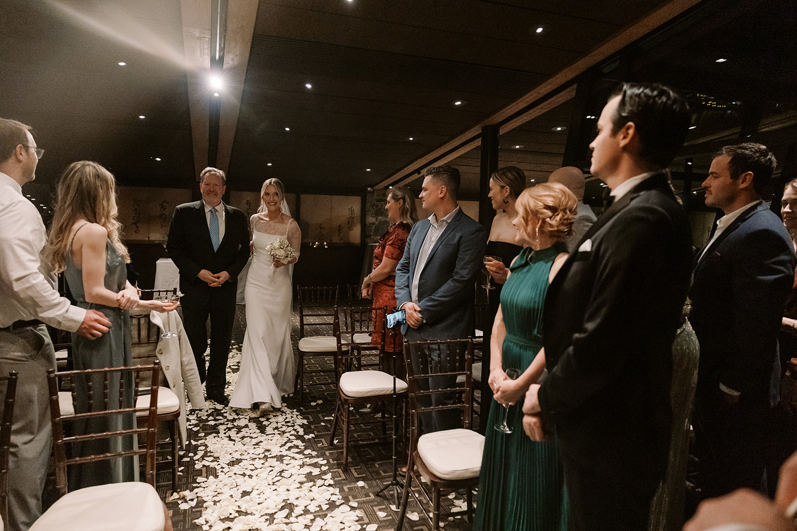 bride walks down aisle of white rose petals during Canlis wedding