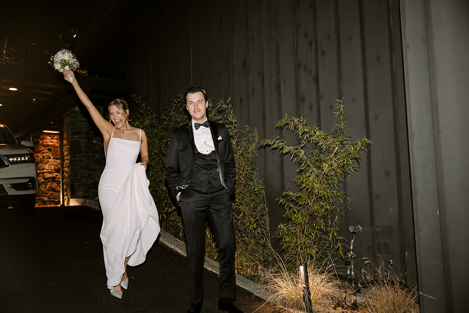 bride and groom walk together smiling at James Bond vibe wedding