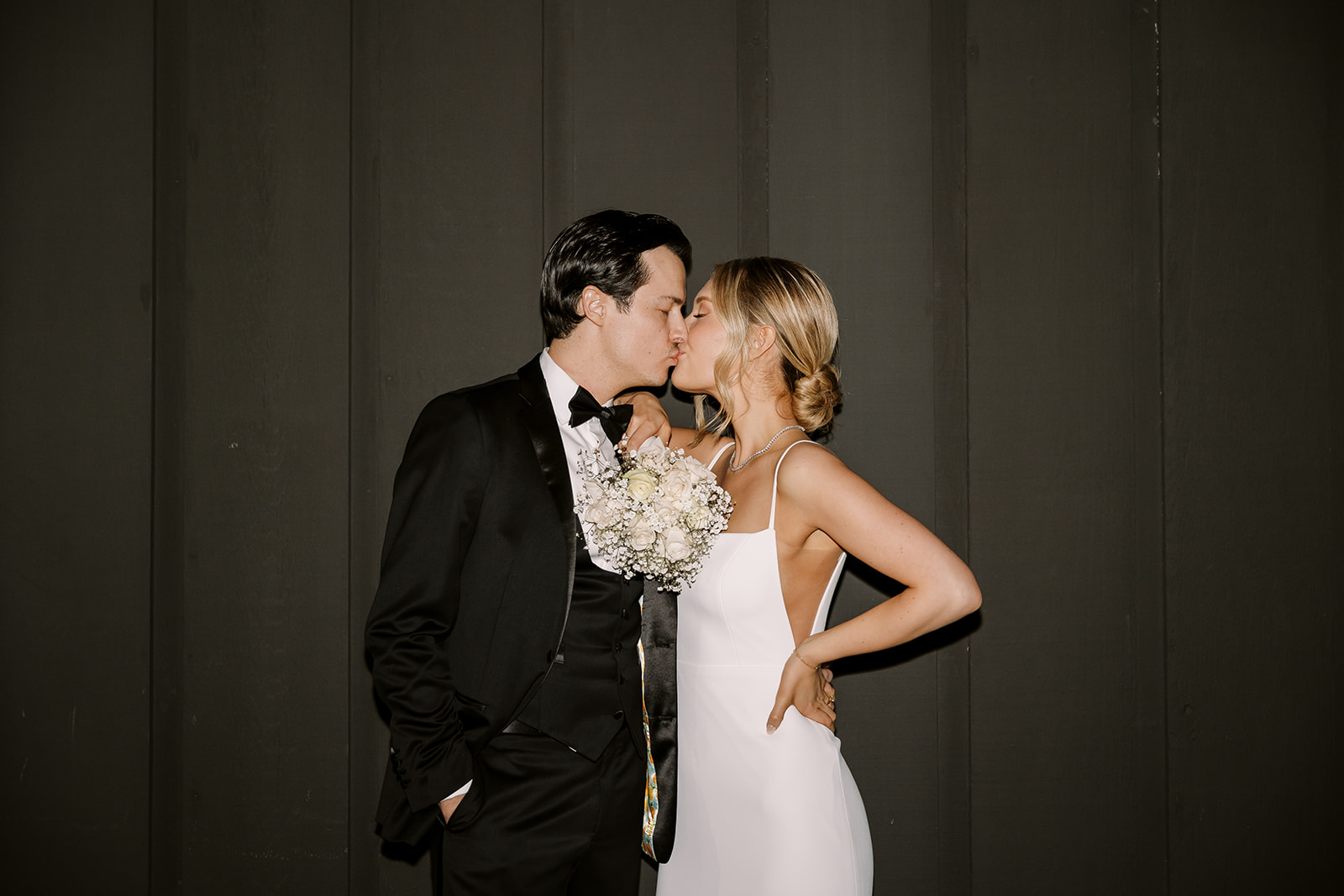 bride and groom kiss while at James Bond vibe wedding