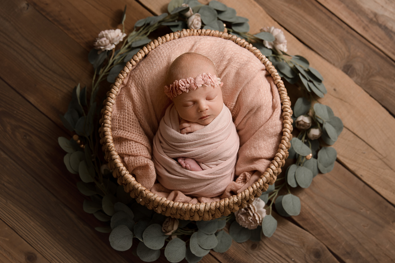 beautiful newborn baby in a basket with flowers