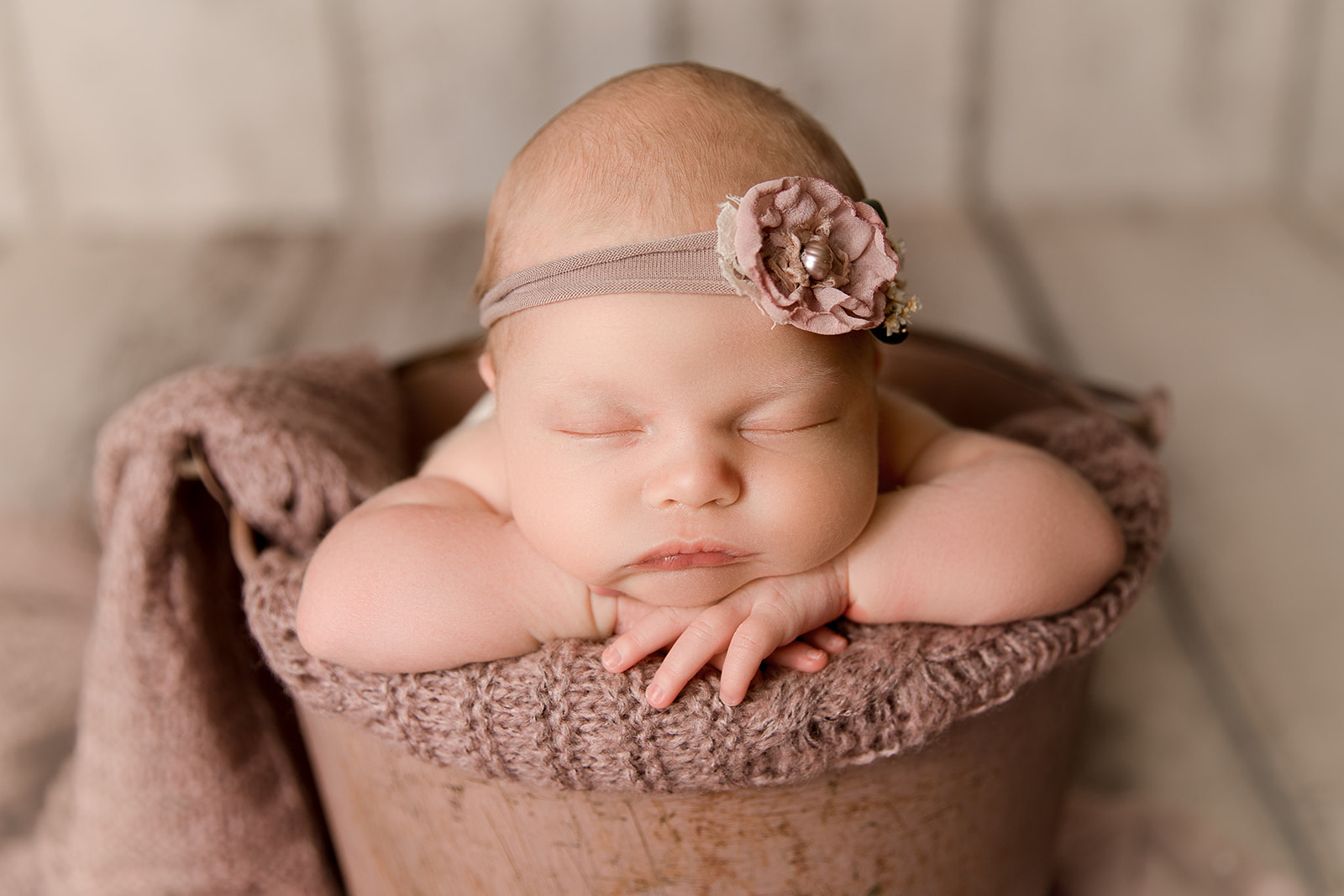 close up of newborns face baby in a bucket pose