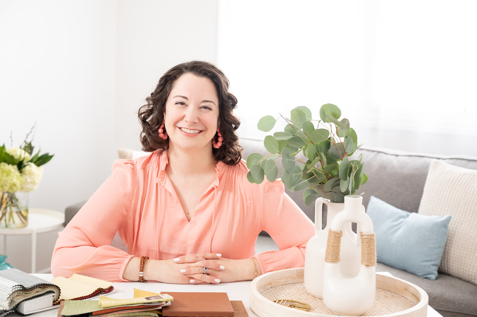 Interior designer smiling at her desk on her lifestyle branding photoshoot for her small business
