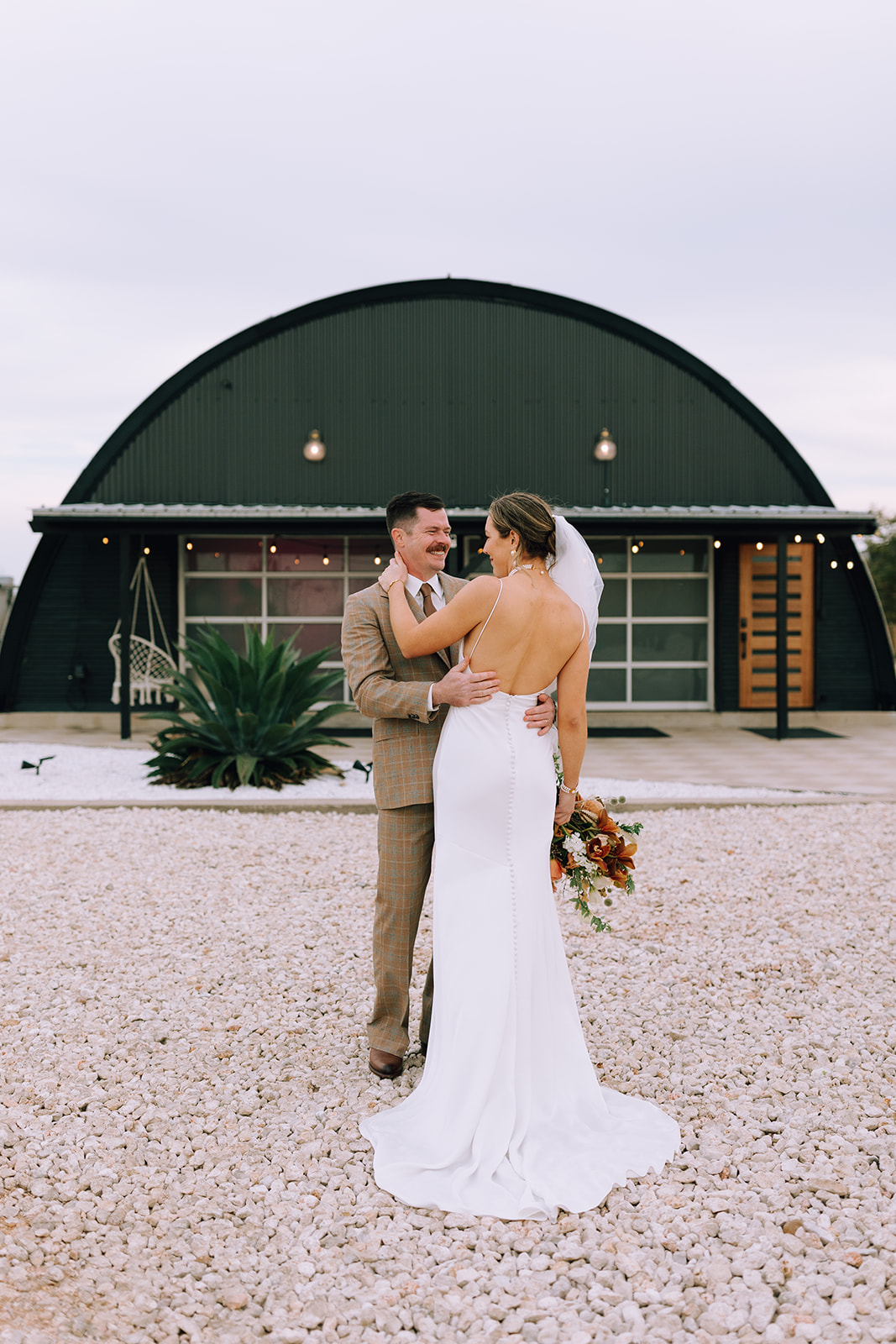 couple embraces at Camino Real Ranch greenhouse wedding venue