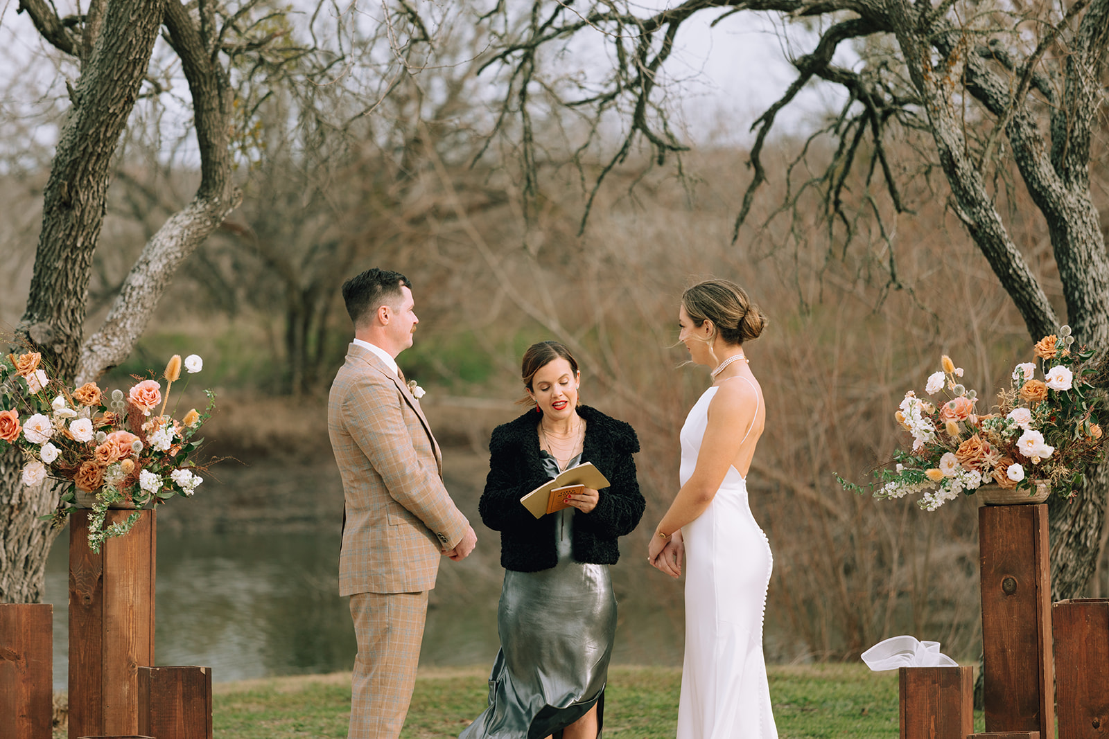couple exchanges vows at outdoor pond ceremony