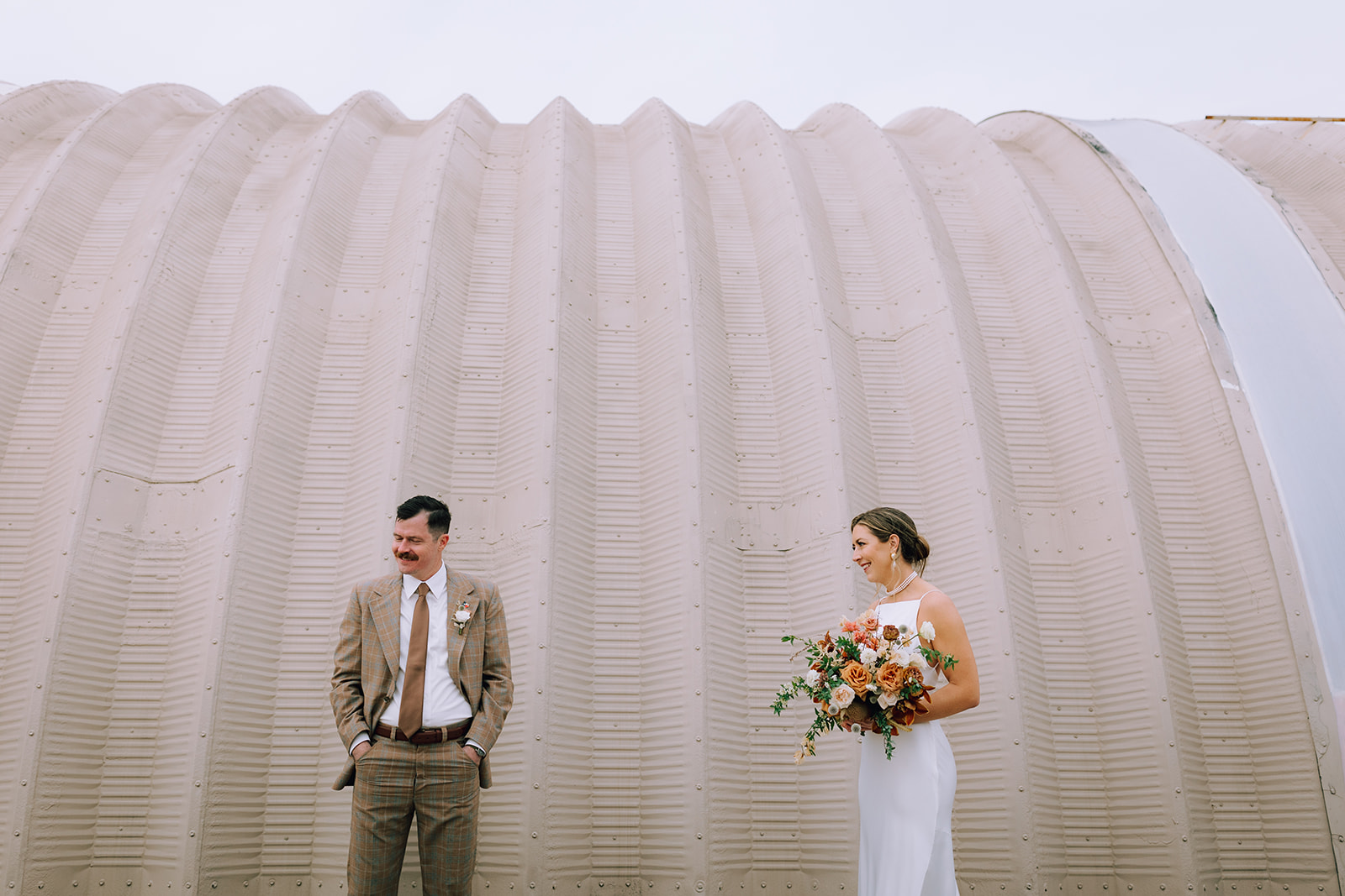 couple poses at Camino Real Ranch greenhouse wedding venue