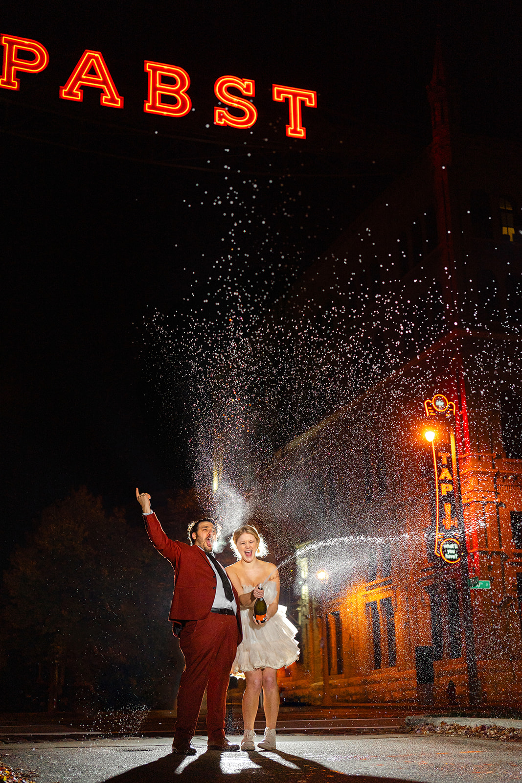 Bride and groom pop champagne bottle outside of The Best Place at the Historic Pabst Brewery