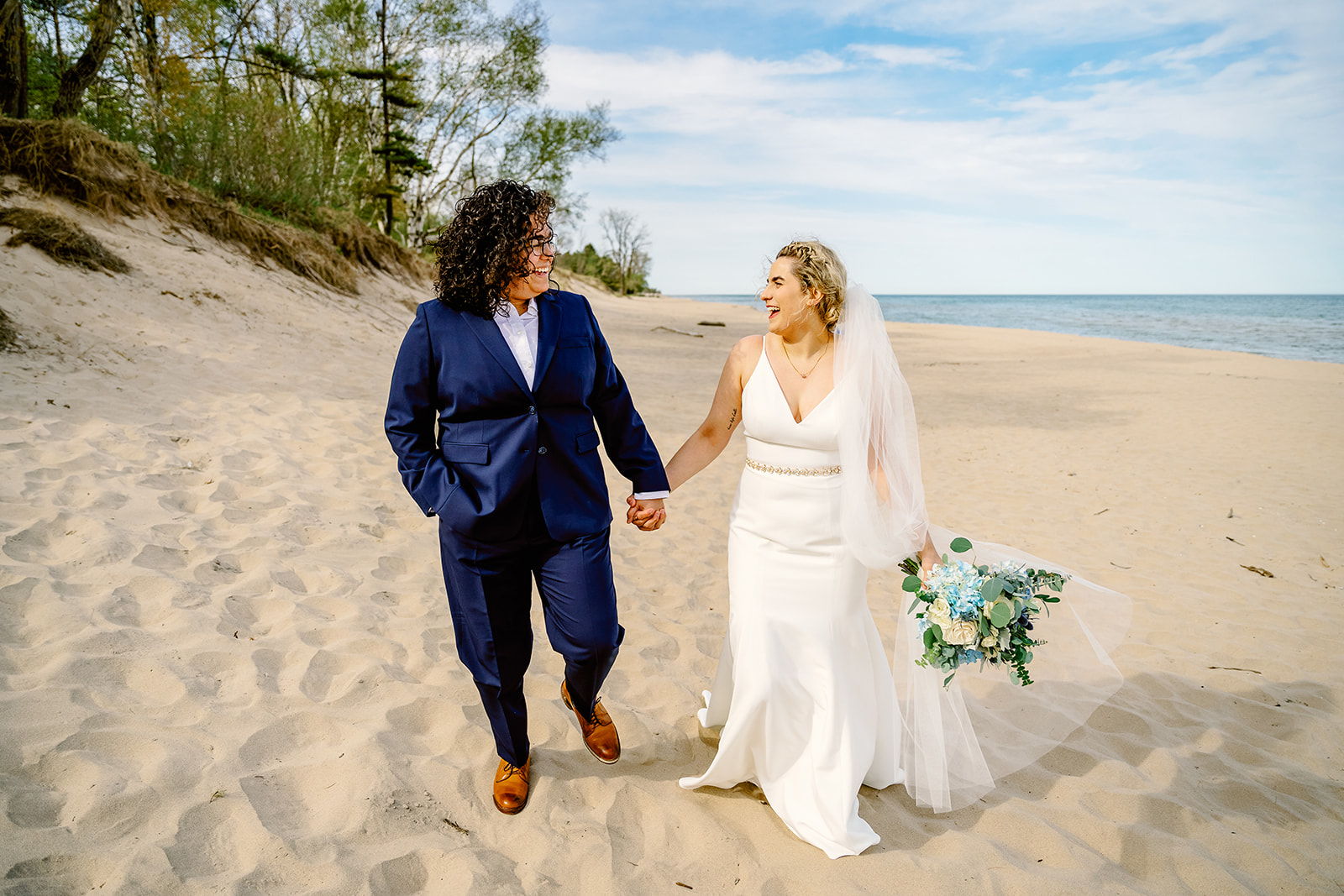 LGBTQ+ couple walks together on their wedding day at Kohler Andre State Park