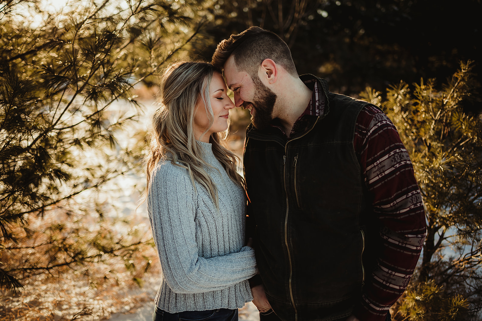 A couple in love take engagement pictures with a beautiful sunset in a Cozy park in Green Bay Wisconsin