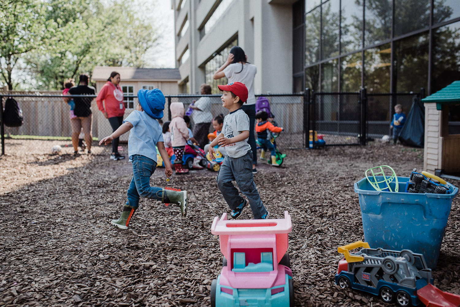 Children are running in the daycare backyard