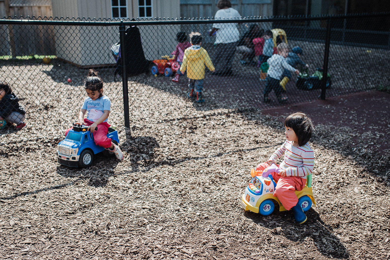 Children are playing in a daycare backyard