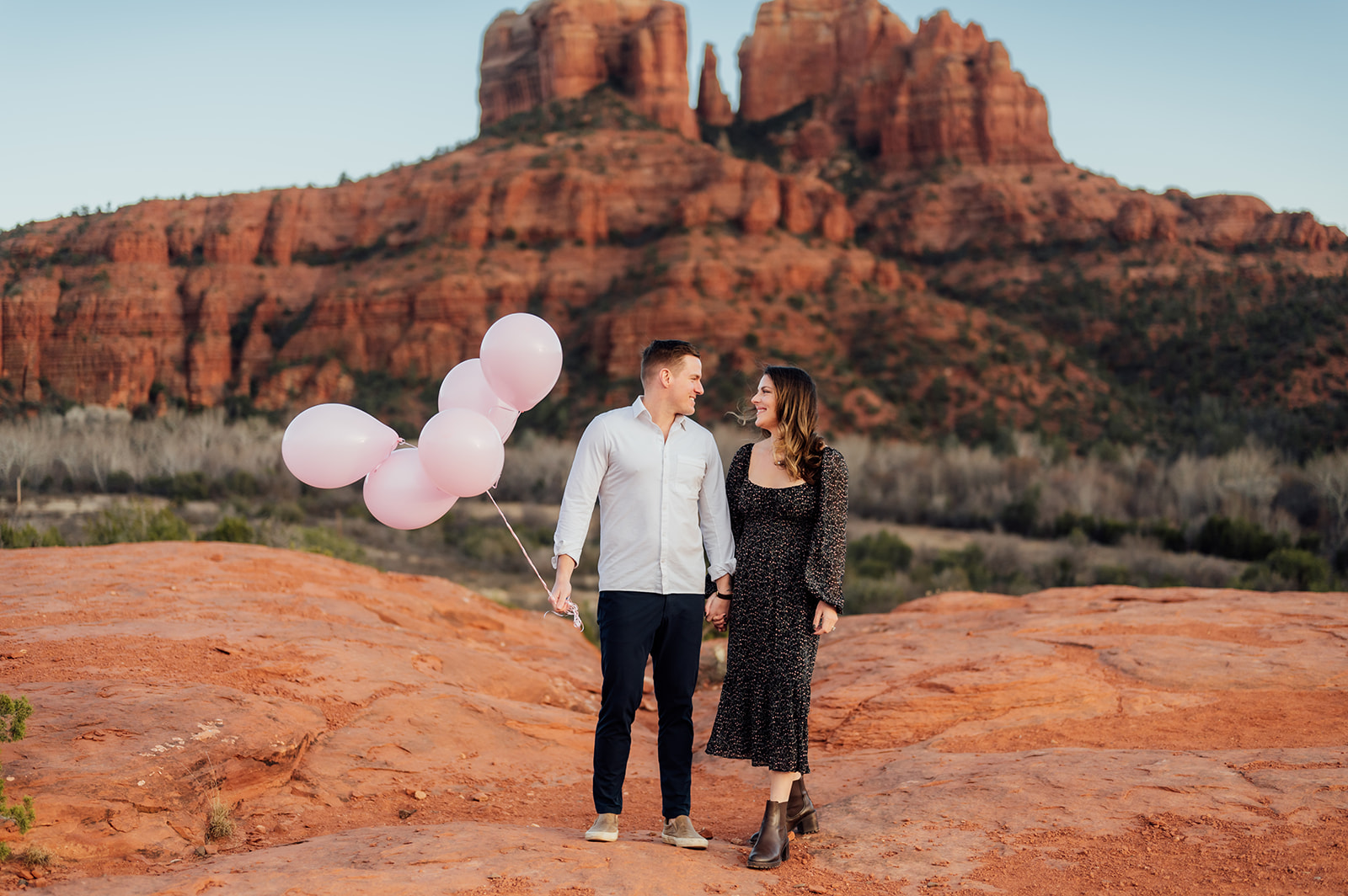 A couple announce the coming of their baby girl with pink balloons on Secret Slick rock in Sedona. 