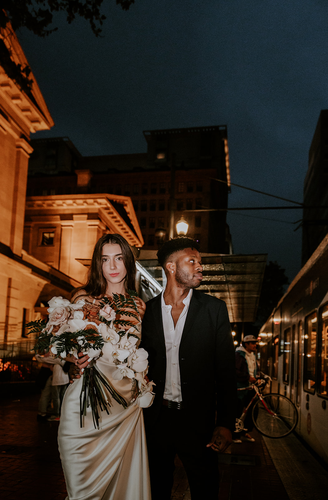 Bride and groom  having flash photos taken at their nighttime elopement in downtown portland