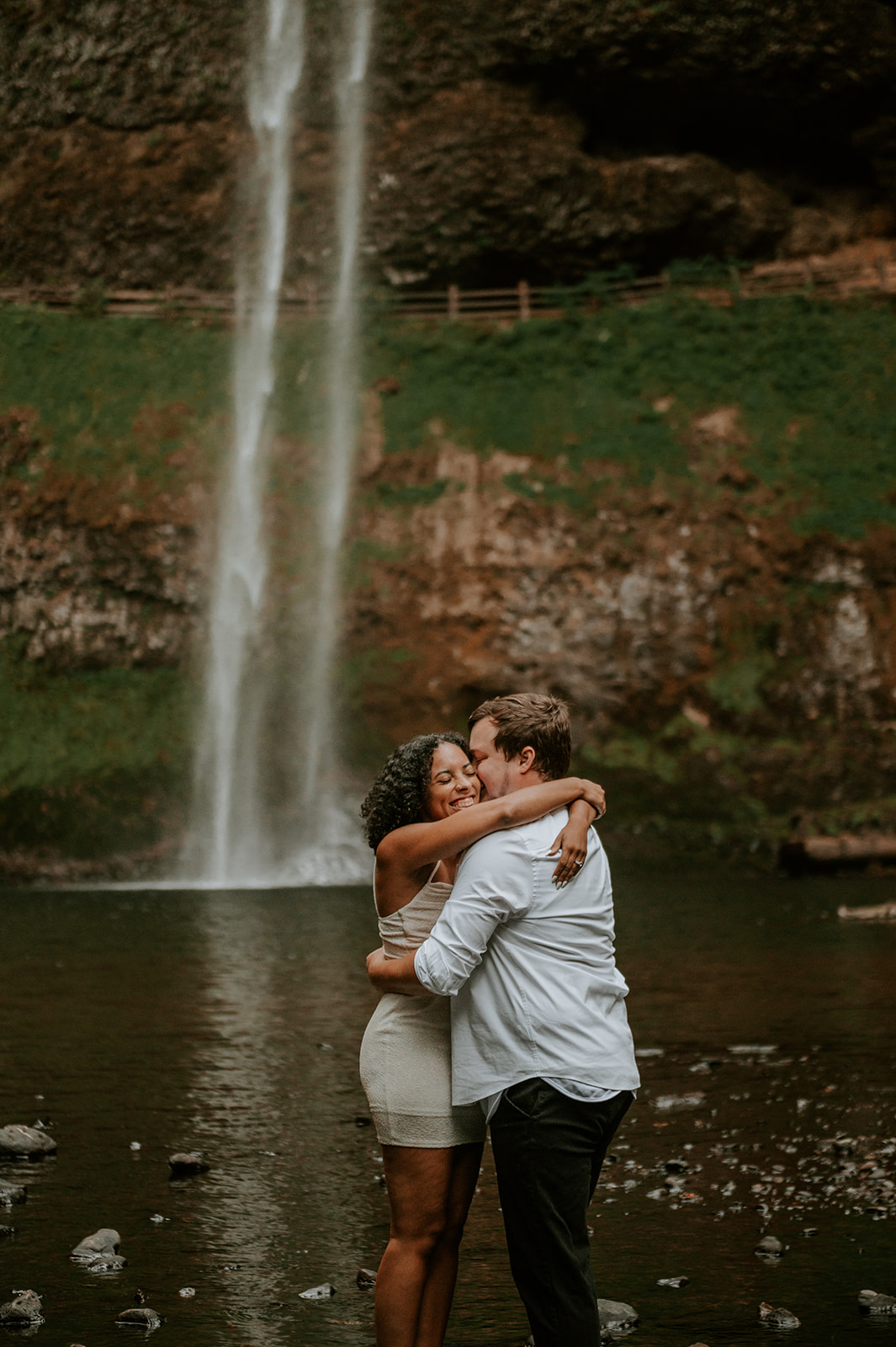 Couple hugging at the base of silver falls state park