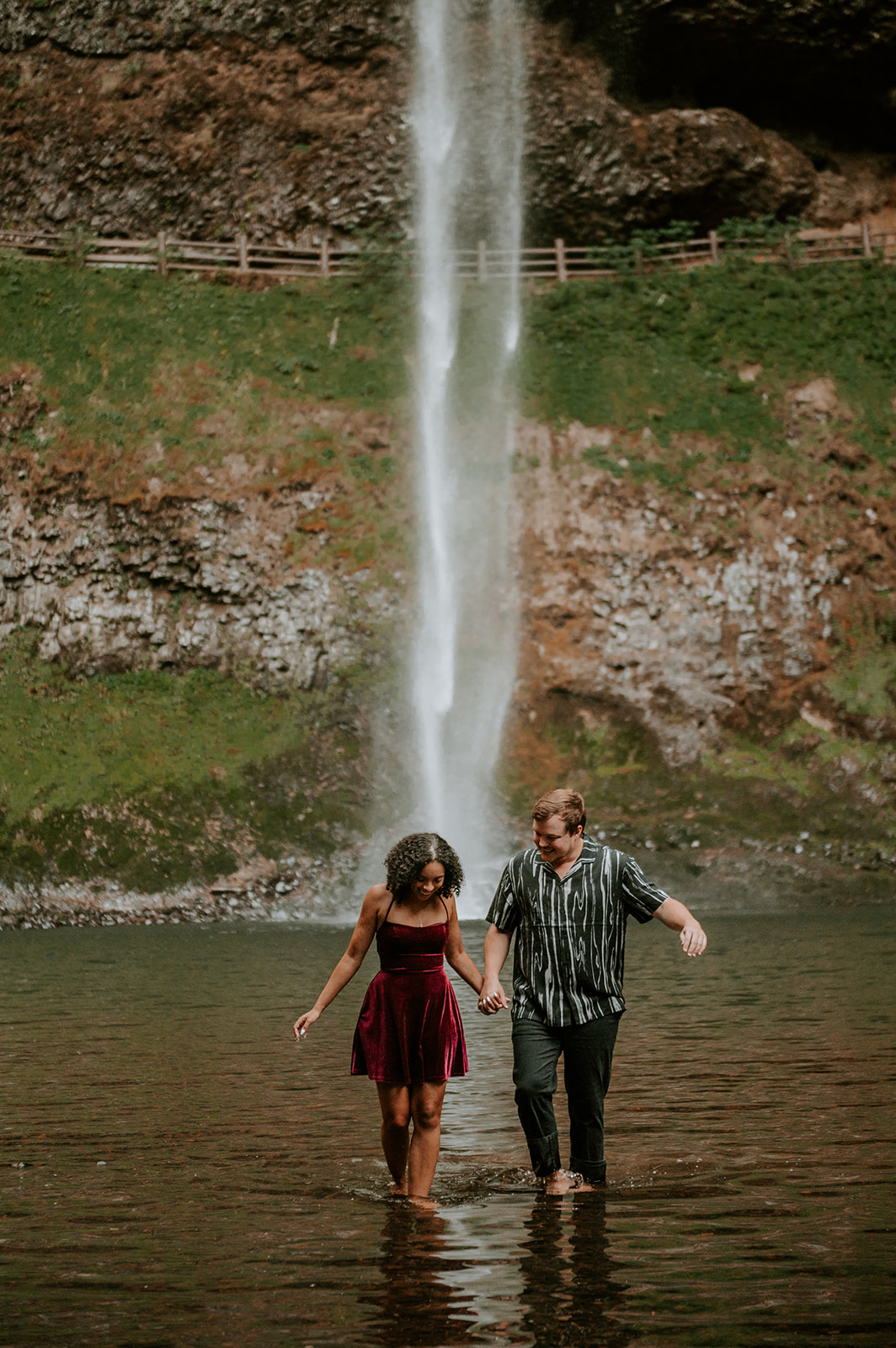 Couple walking in the water at south falls