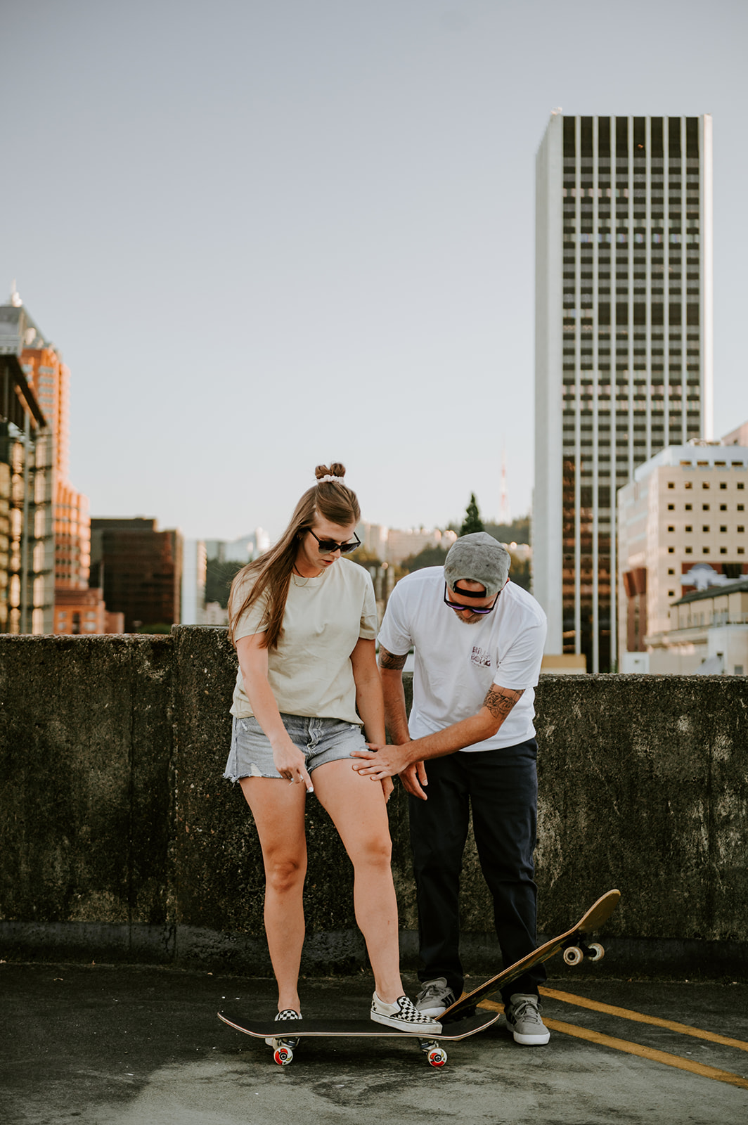 Guy teaching girl how to skateboard engagement session downtown portland