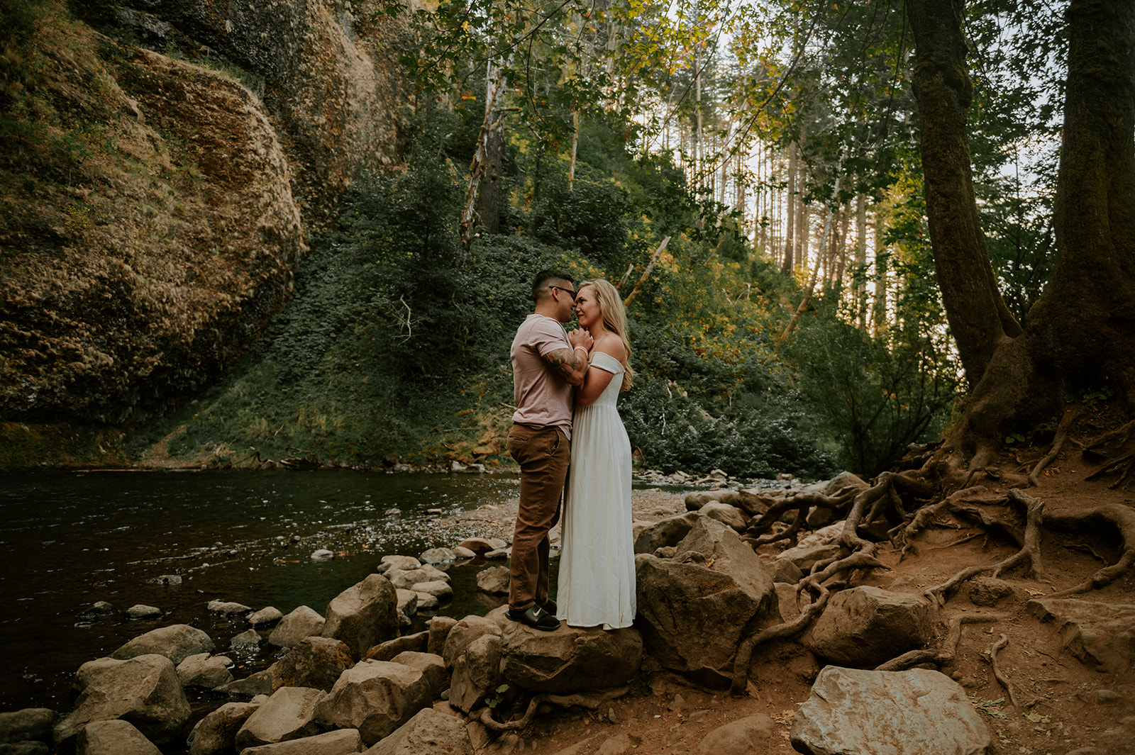 Couple embracing with sun setting behind them at horsetail falls