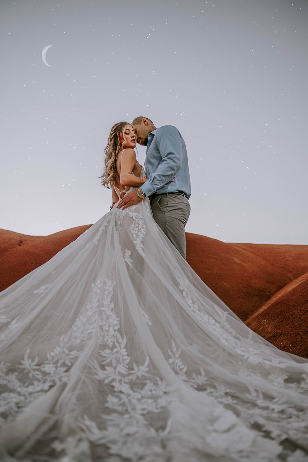 A bride and groom standing forehead to forehead during twilight at the Painted Hills