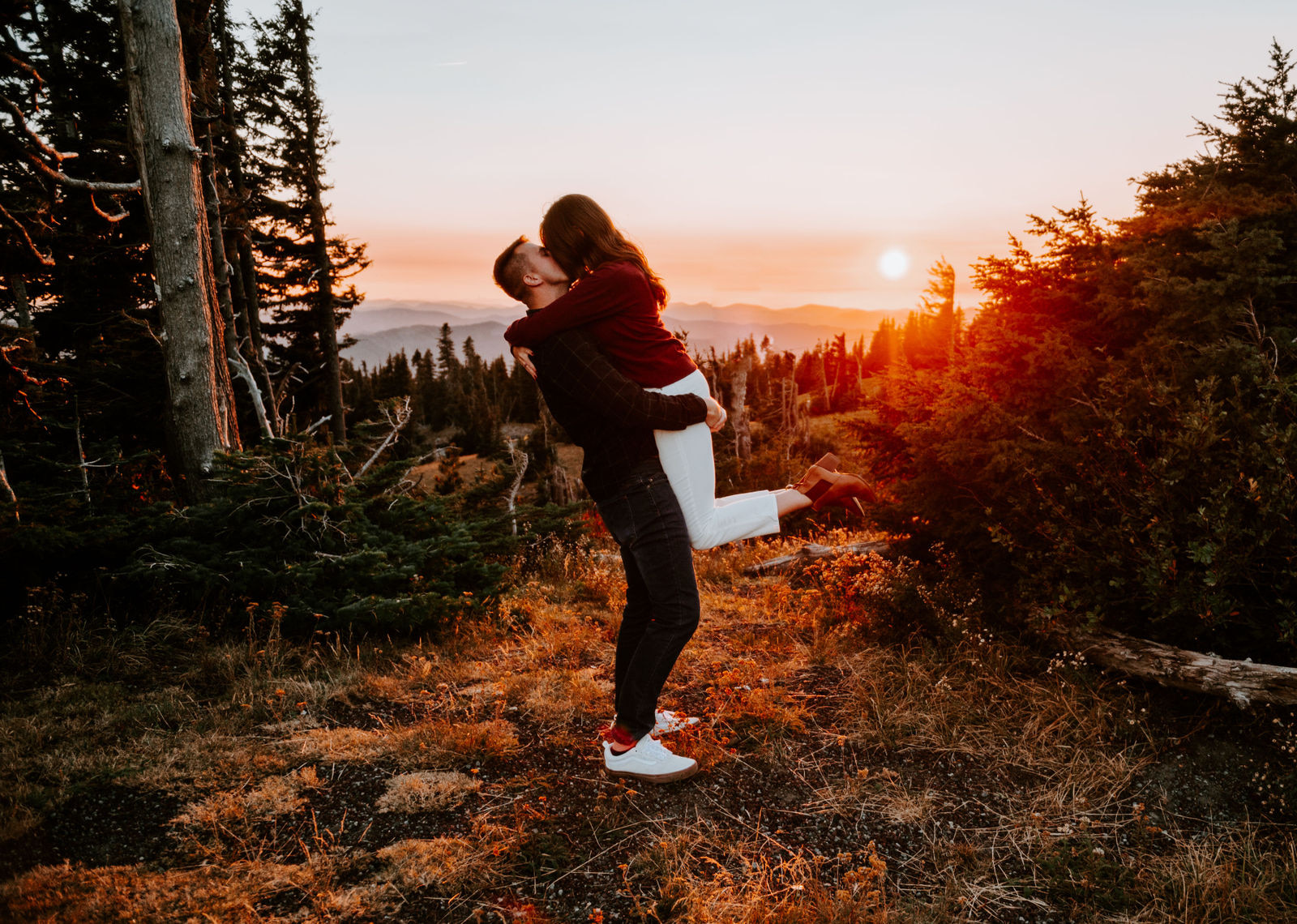 Couple kissing at sunset at timberline lodge overlooking the valley 