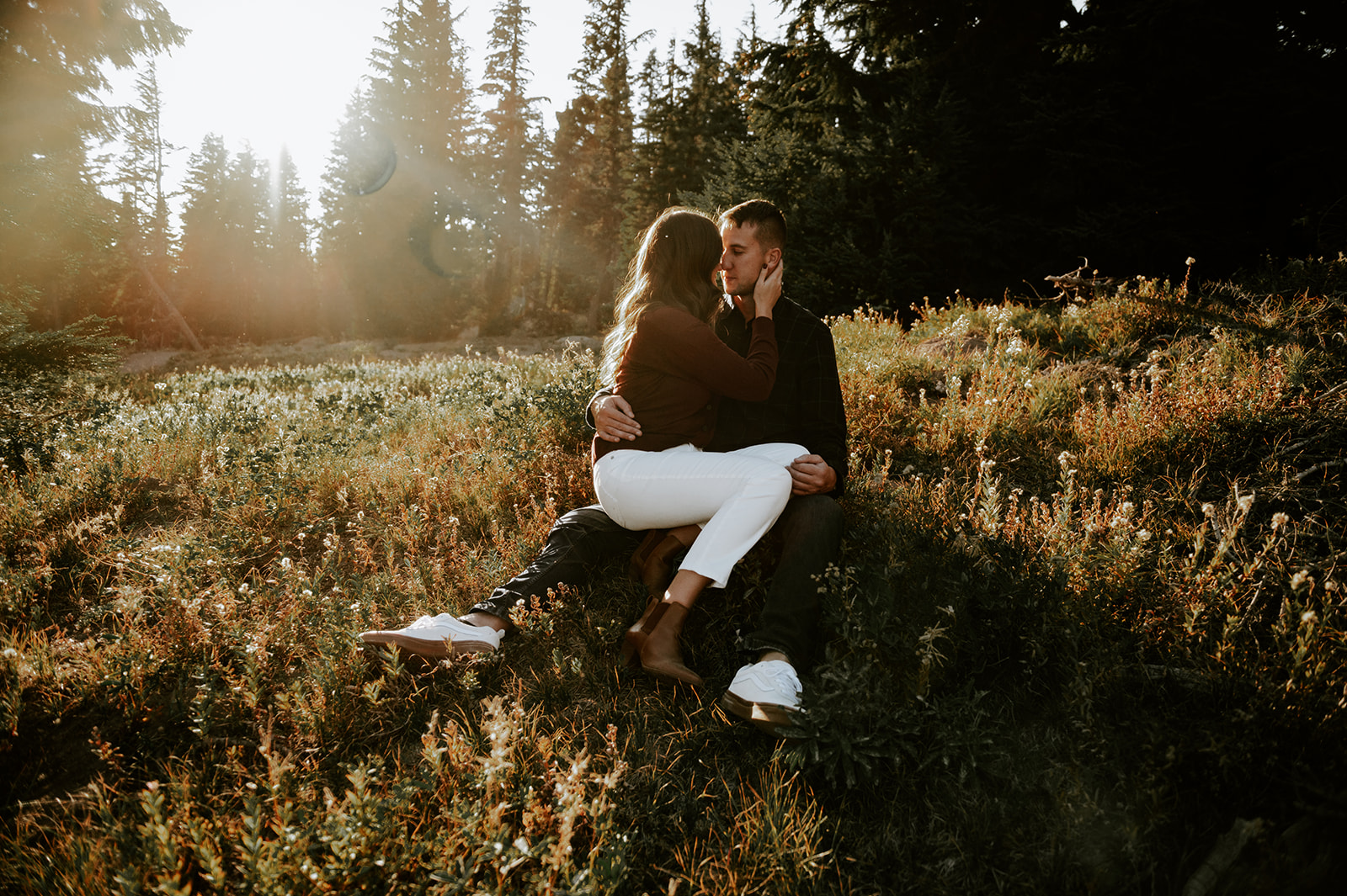 Couple sitting in a meadow at mt. Hood and embracing