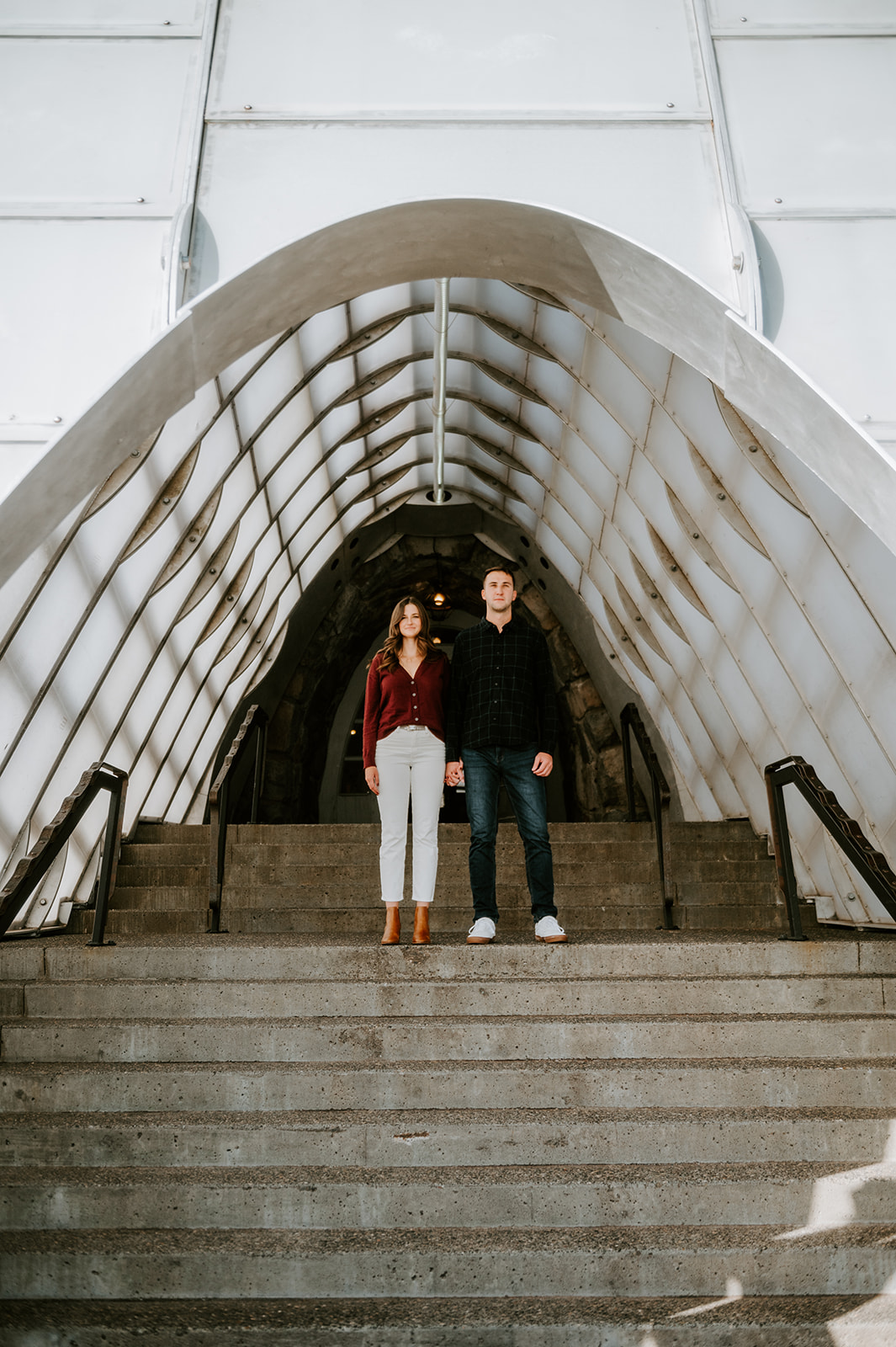 Couple standing in front of the Timberline Lodge tunnel entrance and looking at the camera
