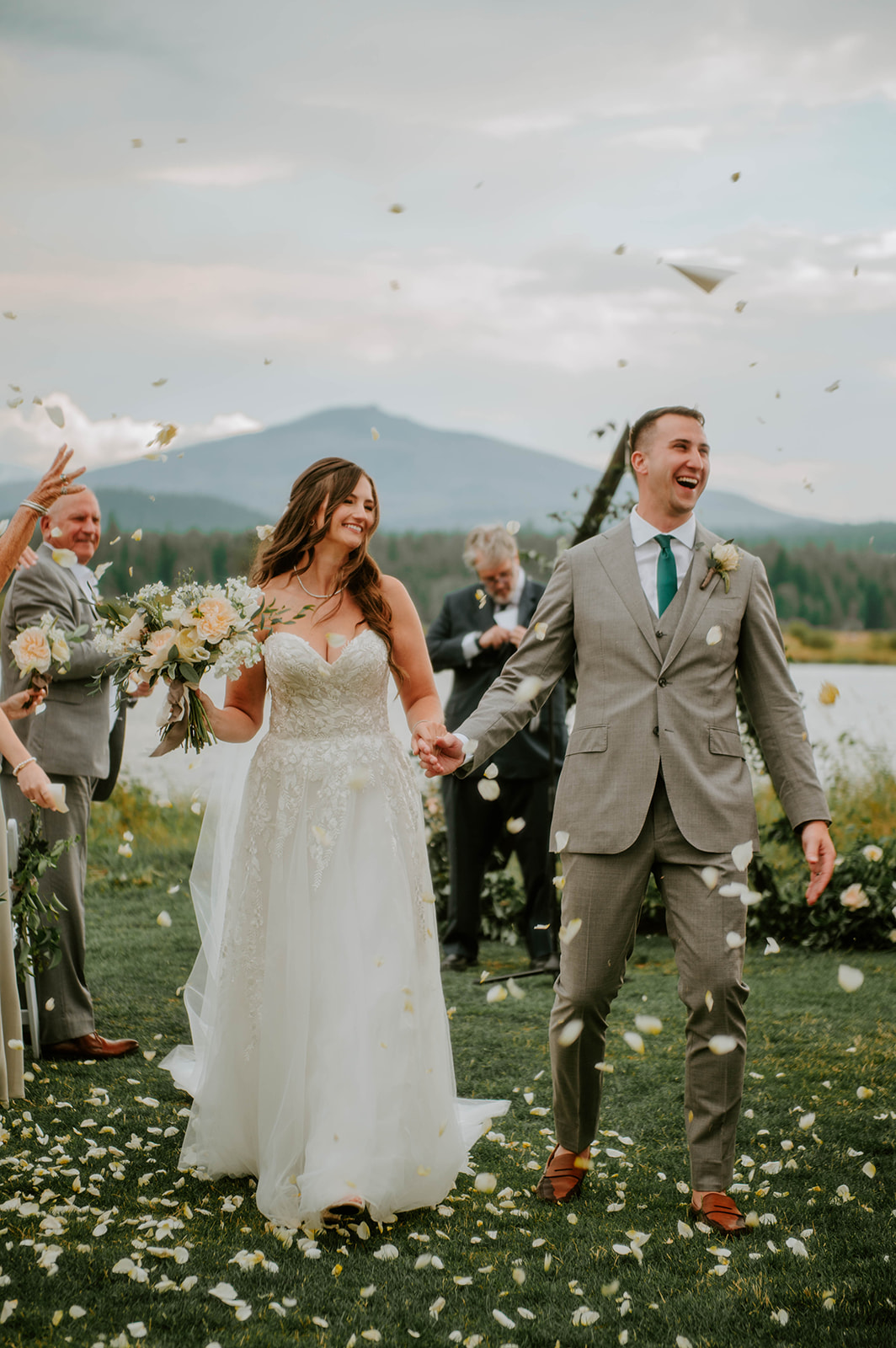 Bride and groom walking through petals after the ceremony at black butte ranch