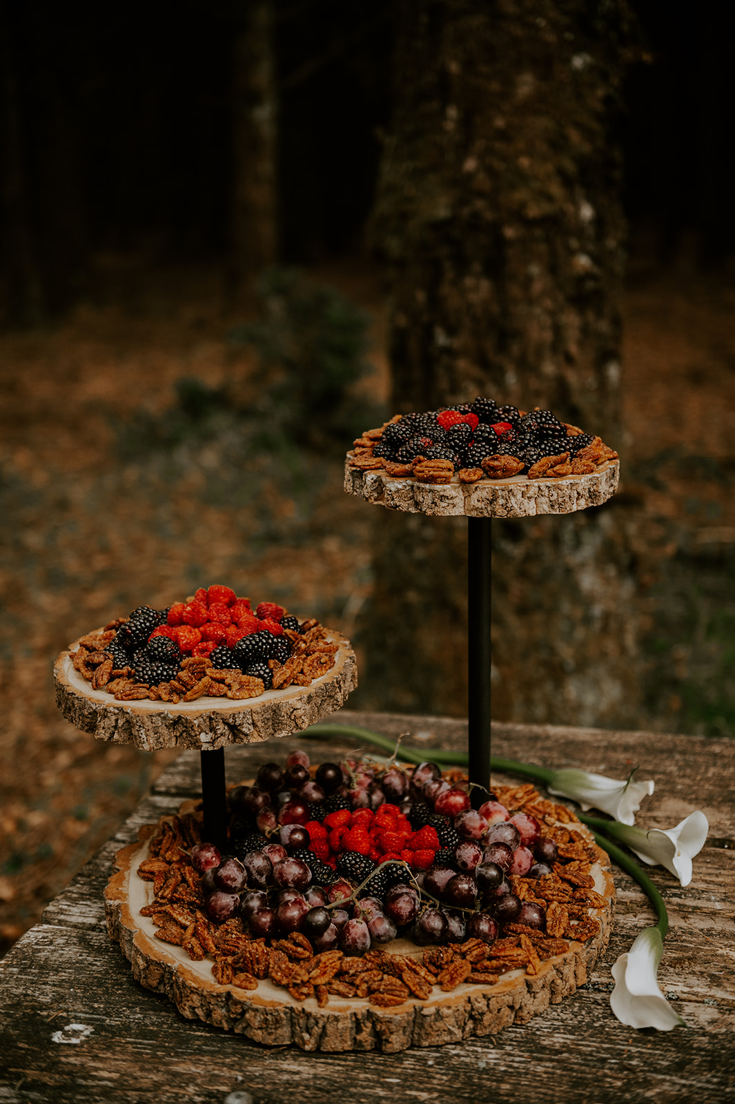 Vegan healthy wedding desert ideas. Berries and nuts on tiered wooden rounds