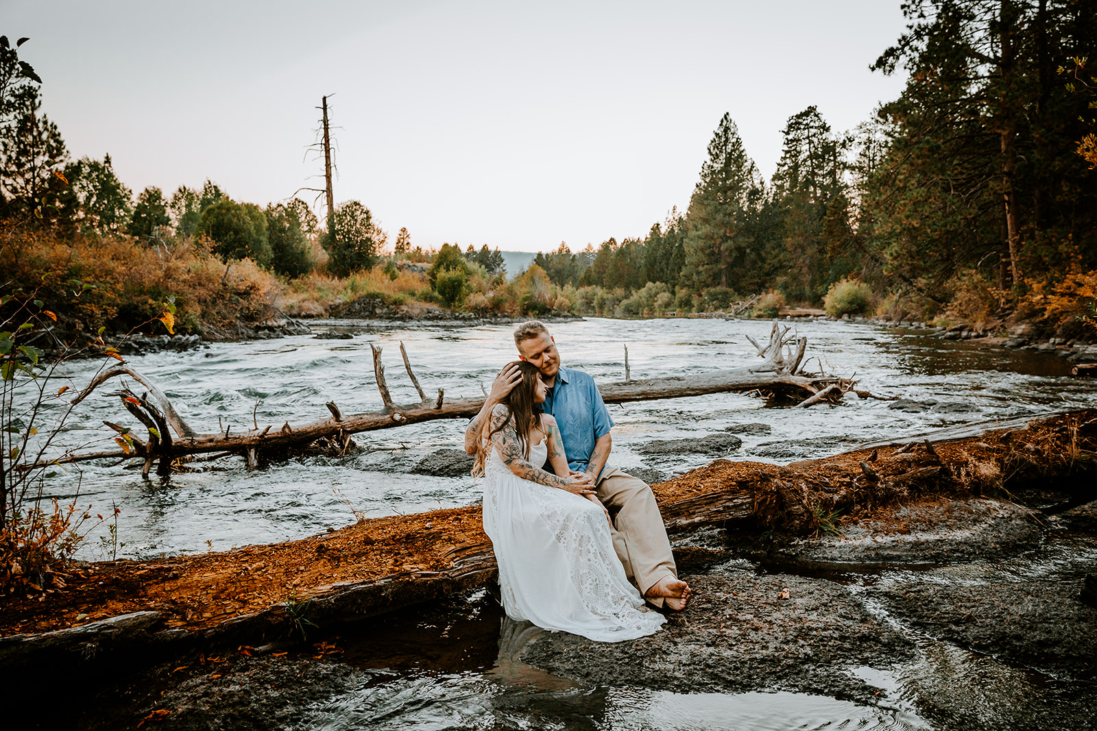 Bride and groom embracing and sitting together at Dillon falls