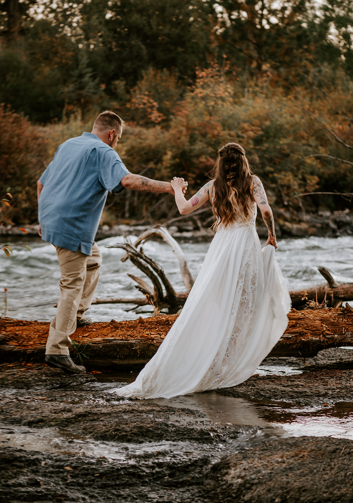 Bride and groom walking into the river during vow renewal at Dillon falls