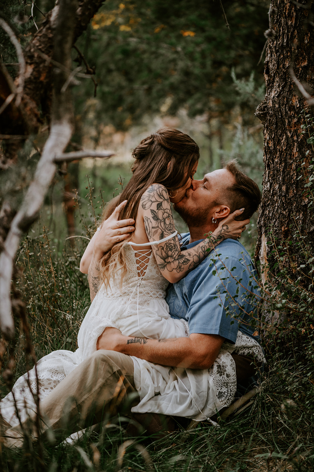 Bride straddling groom and kissing him in the trees at Dillon falls in bend 