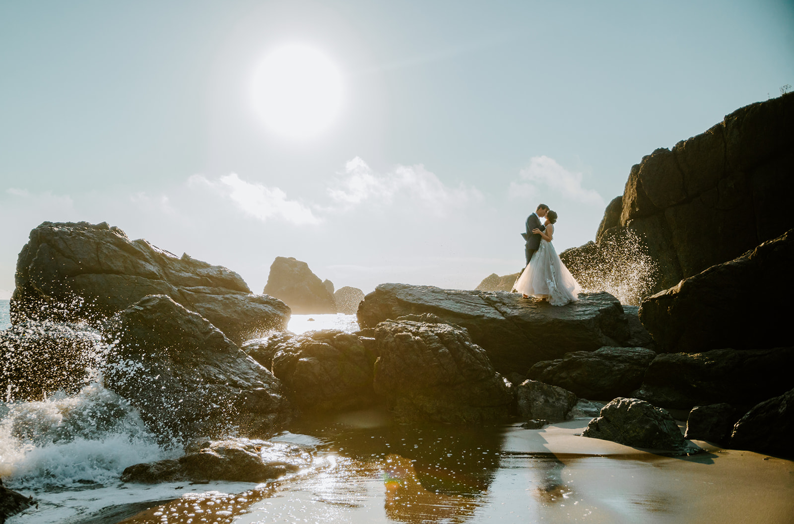 Bride and groom kissing as the waves crash on Lone Ranch Beach at Samuel H Boardman State Park on the Oregon Coast