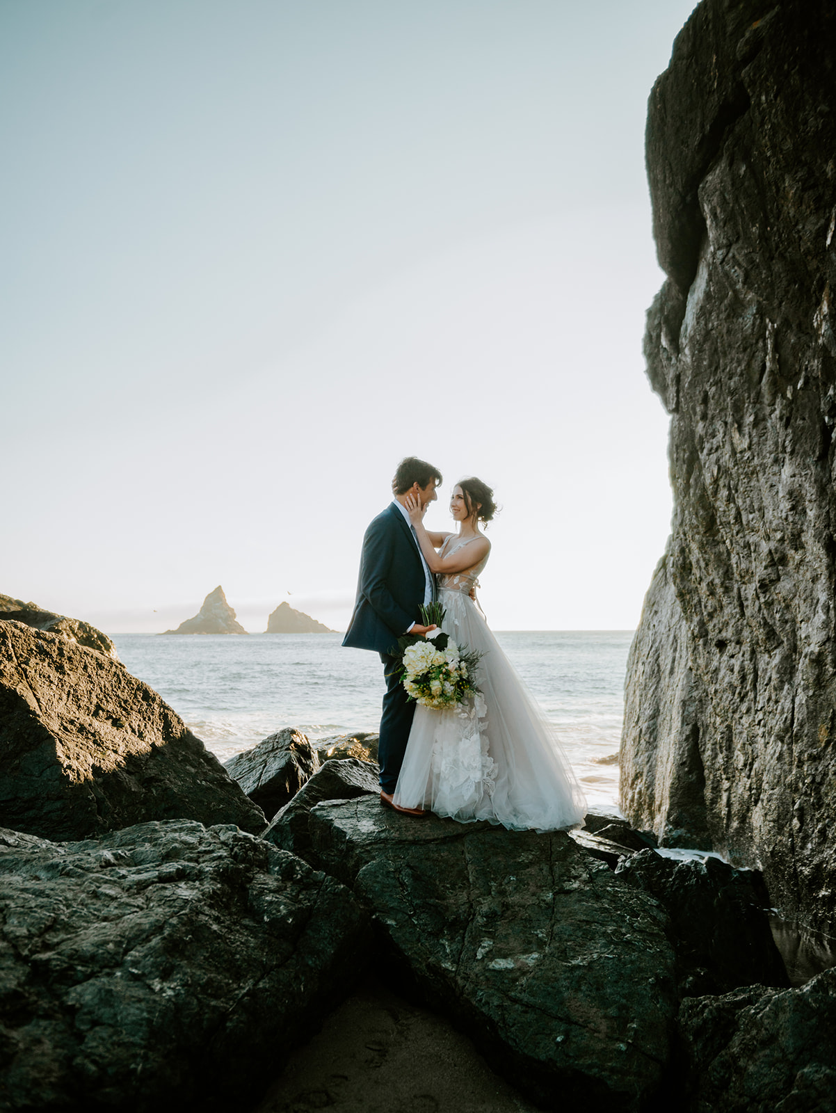 Bride and groom kissing as the waves crash on Lone Ranch Beach at Samuel H Boardman State Park on the Oregon Coast