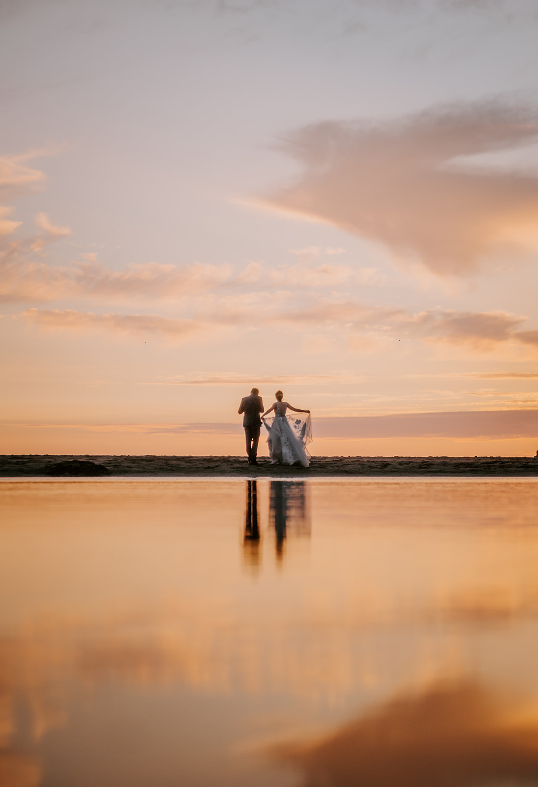 Bride and groom at sunset in the distance