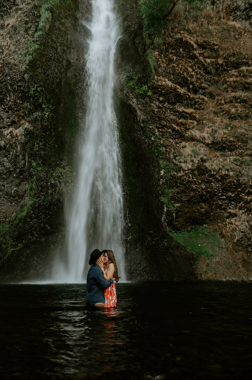 couple kissing for engagement photos at the base of horsetail falls in the Colombia river gorge 
