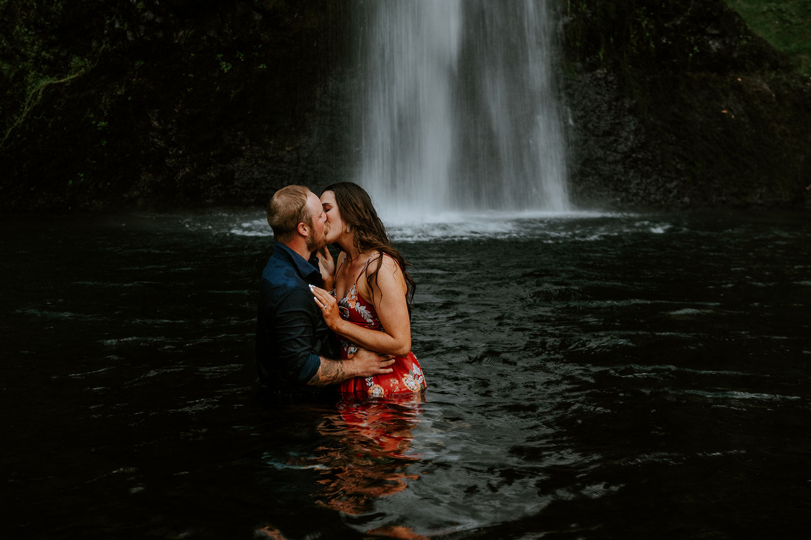Couple kissing at the base of horsetail falls in the colombia river gorge