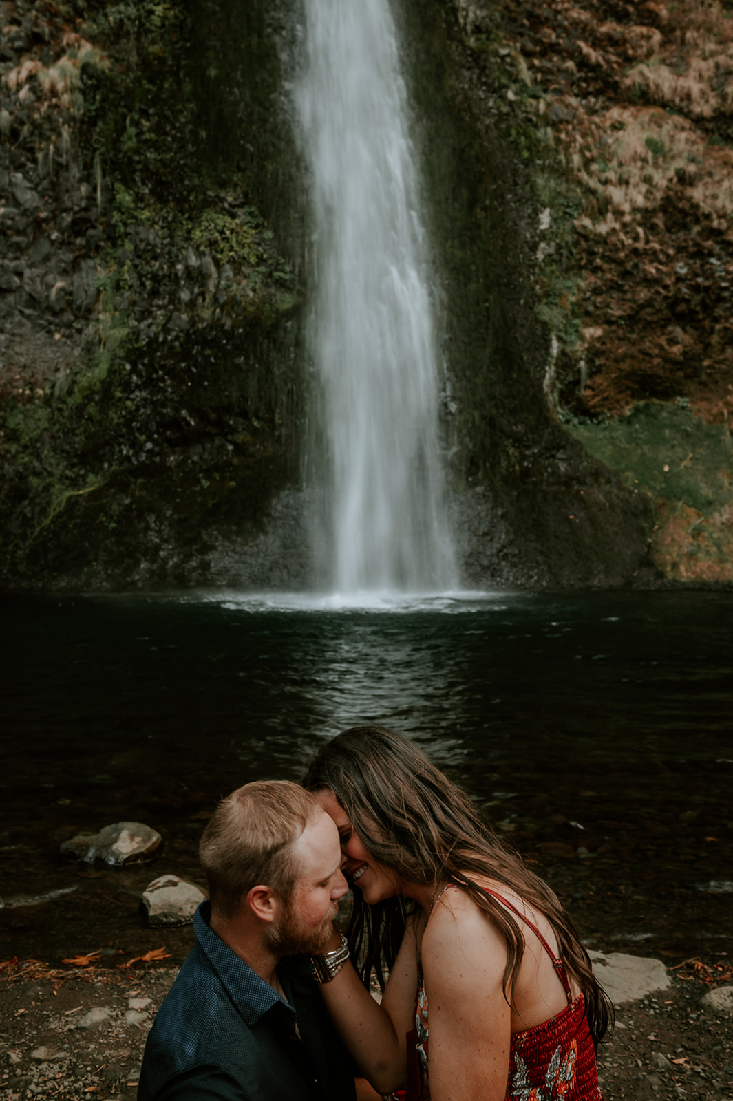 Couple kissing at the base of horsetail falls for their engagement photos