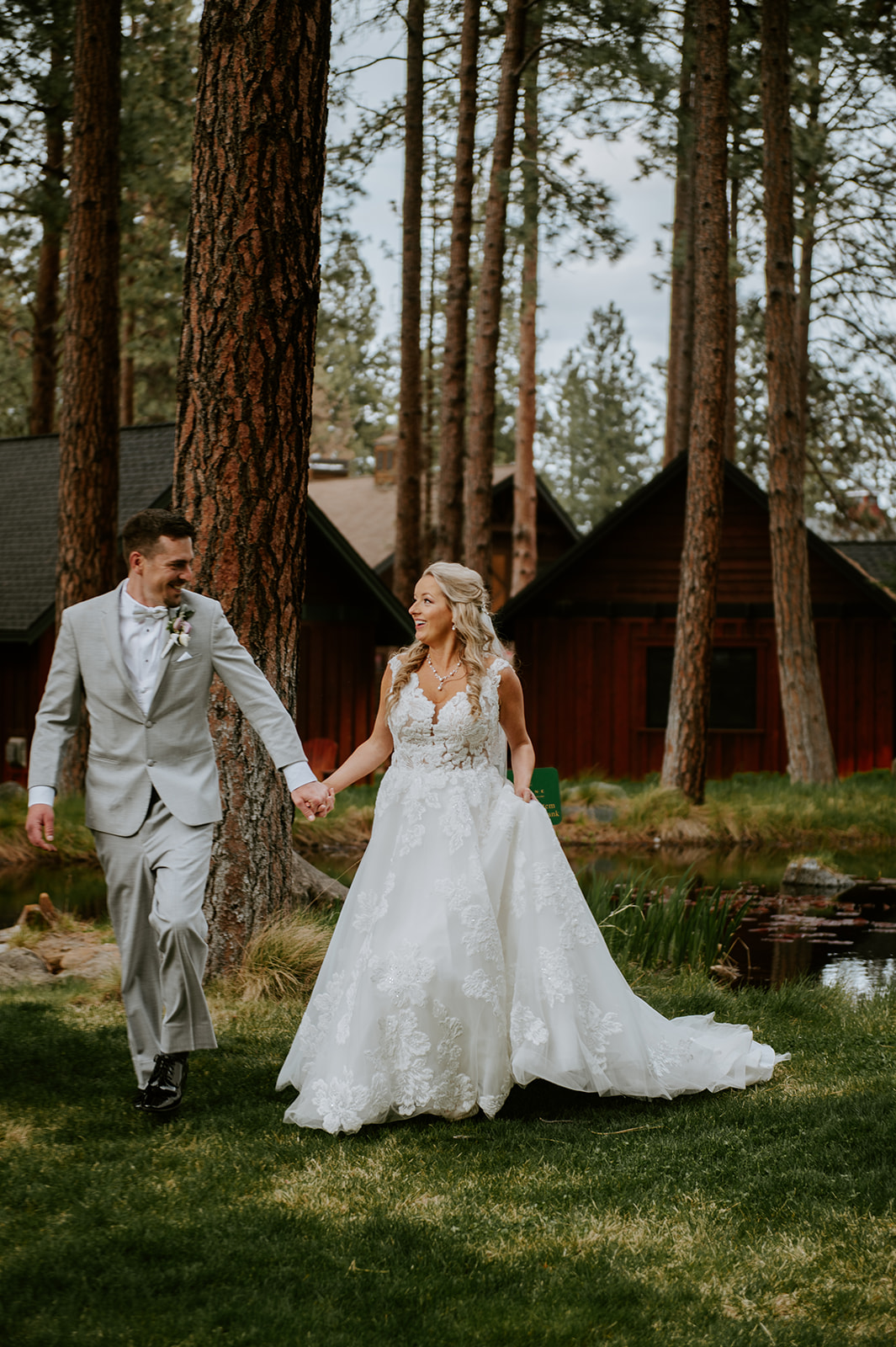 Bride and groom walking together and holding hands in the tall pine trees in sisters oregon