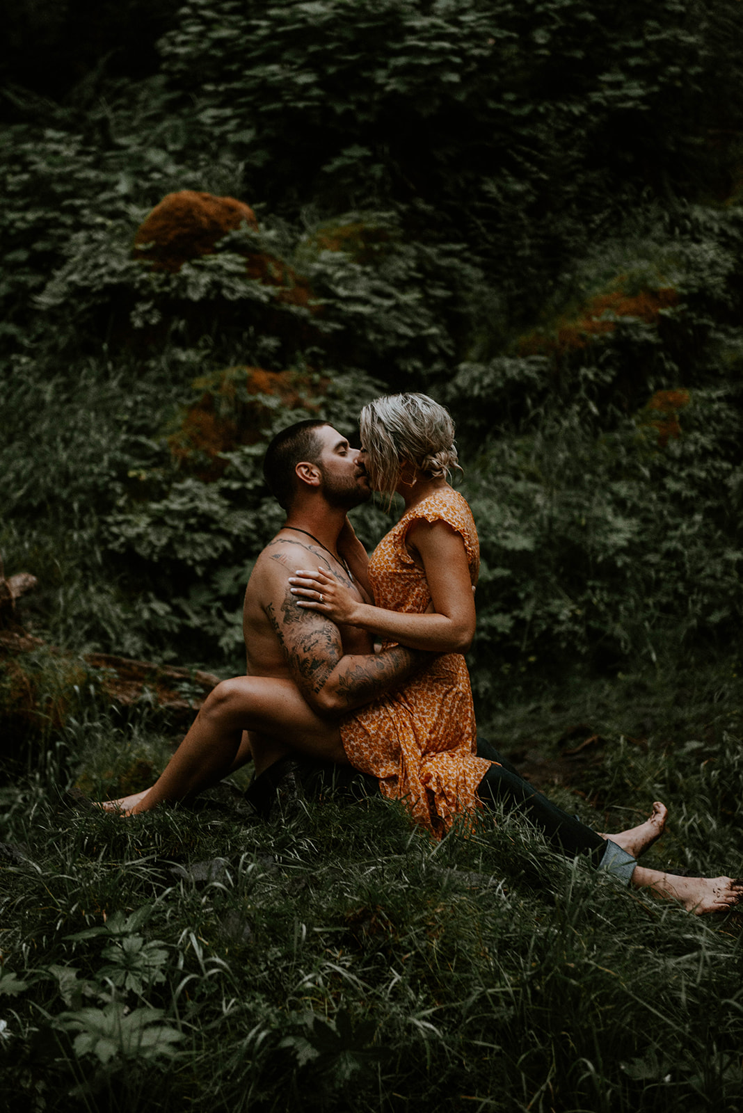 A couple embracing on the ground at their engagement photo session in Oregon