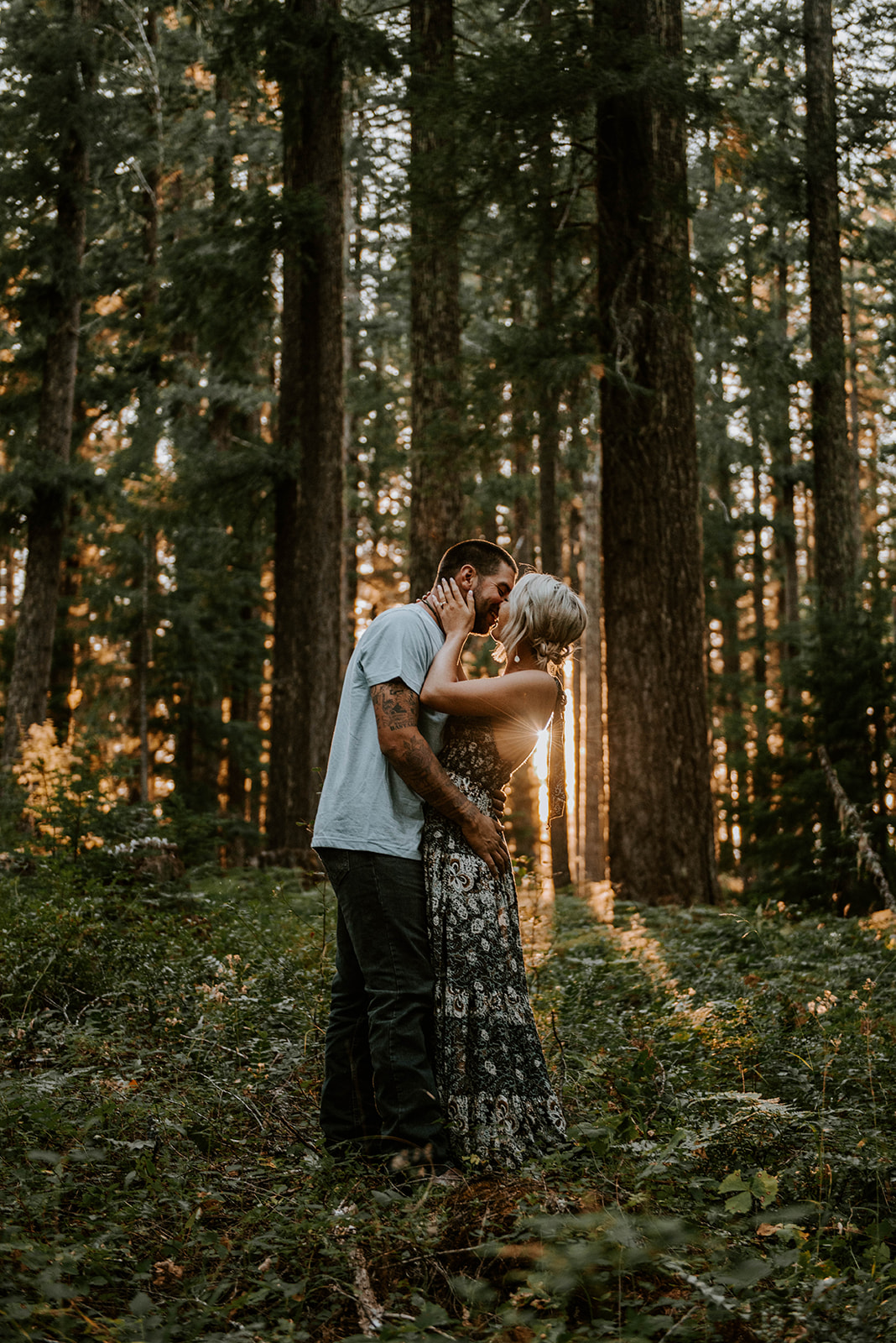 A couple kissing at golden hour in the old growth forest in the Pacific Northwest
