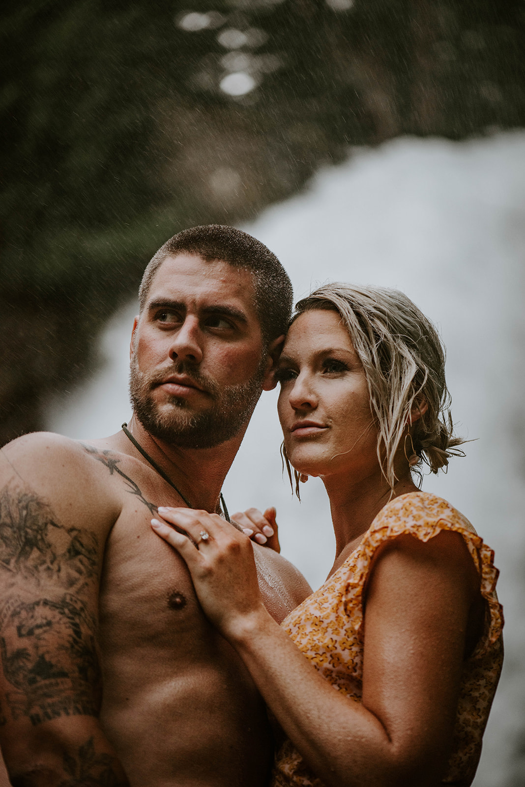 A couple standing together in the mist of a waterfall