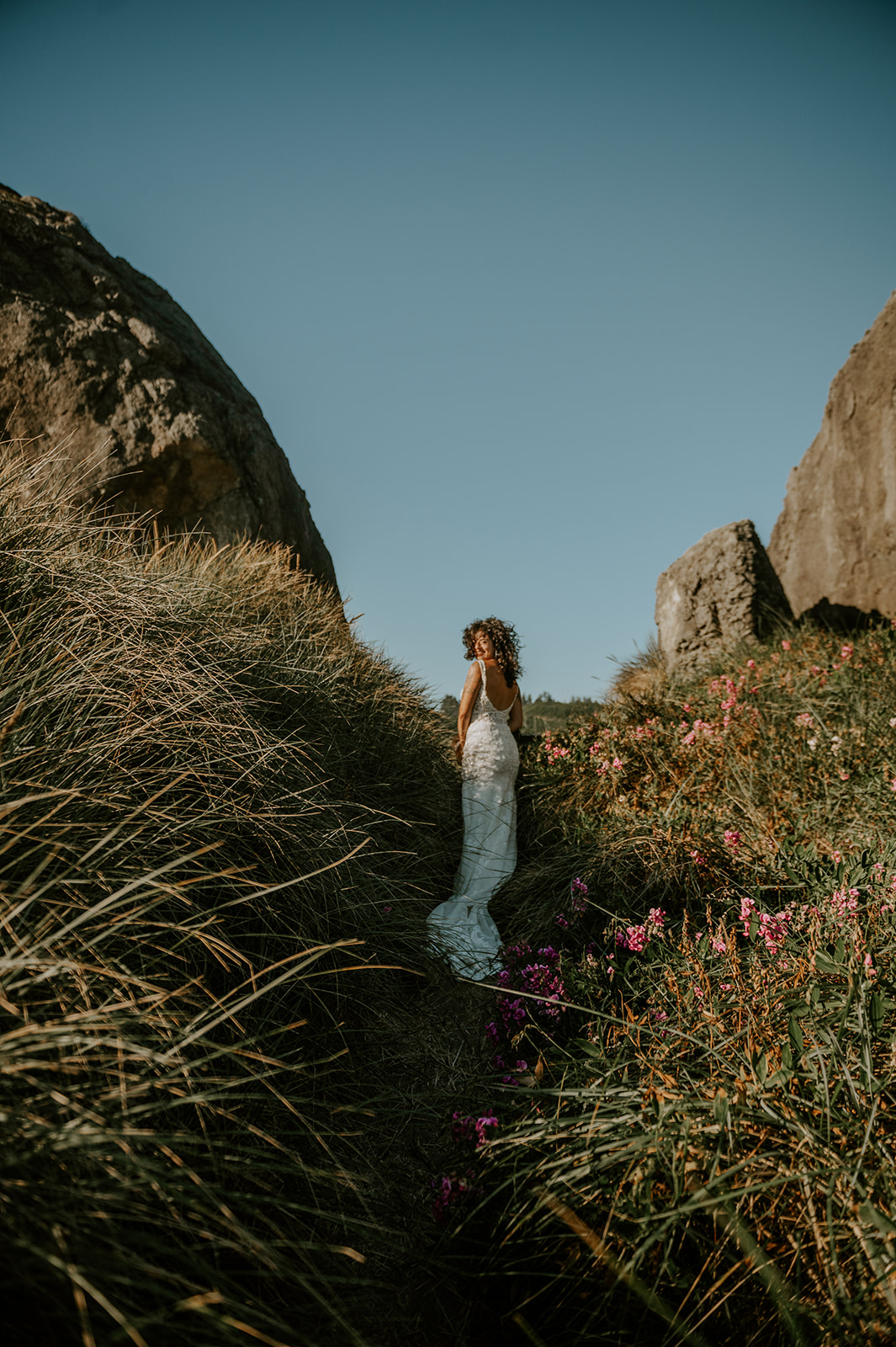 Oregon coast bride walking through the wild flowers at kissing rock 