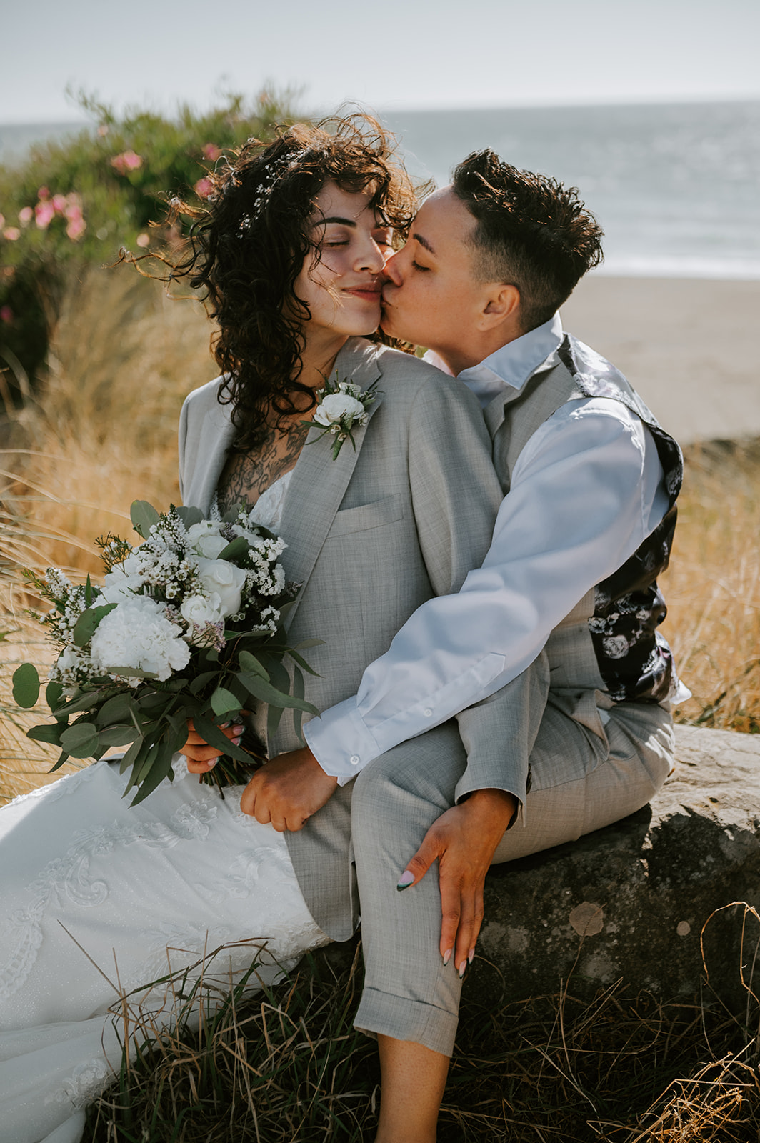 Two brides kissing at kissing rock on the Oregon coast
