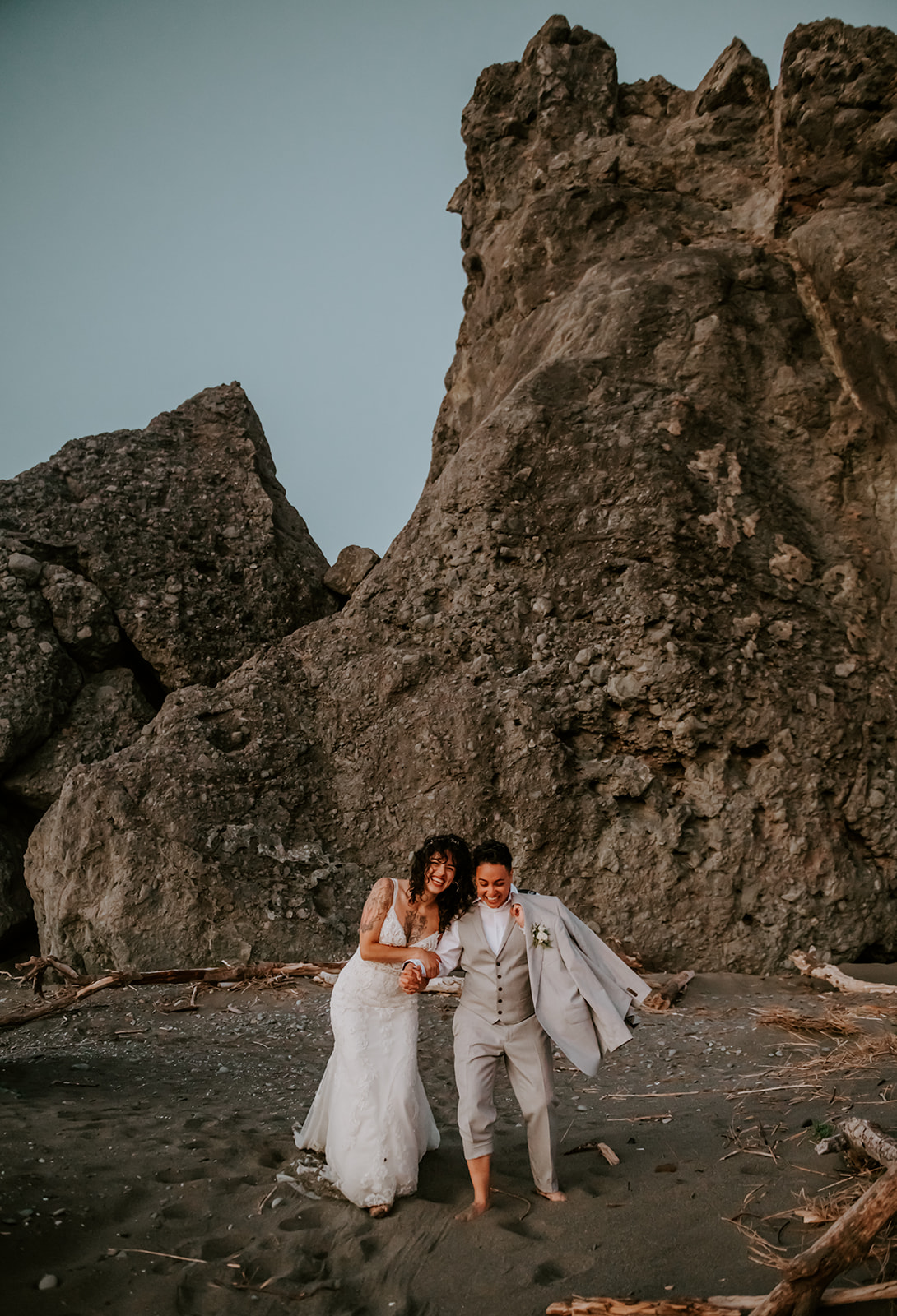 Two brides running on the beach at kissing rock on the Oregon coast