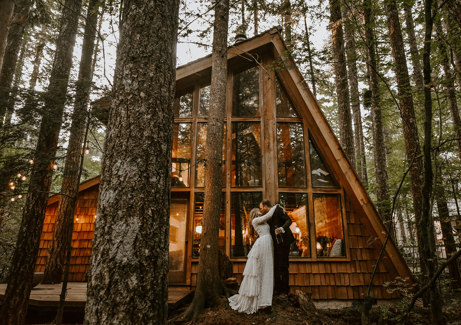 A couple who eloped kissing in front of an A-Frame Cabin in Oregon