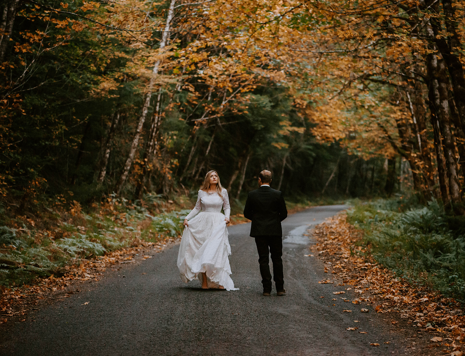 A couple who eloped walking through the autumn leaves in Oregon after they said their vows.